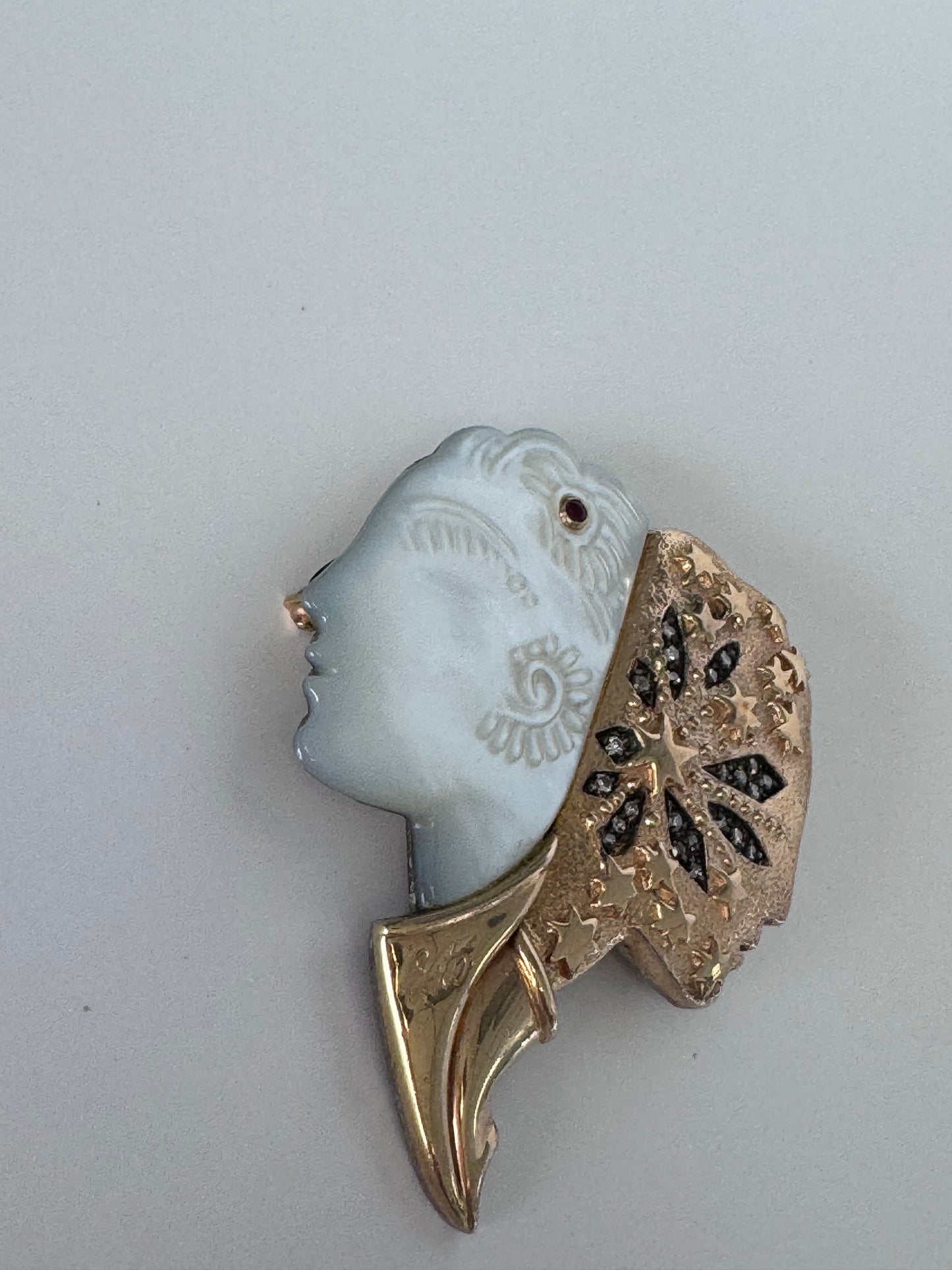 Erté Nuit et Jour brooch with carved mother of pearl dual profiles, sterling silver textured body, 14K gold diamond foliate accents