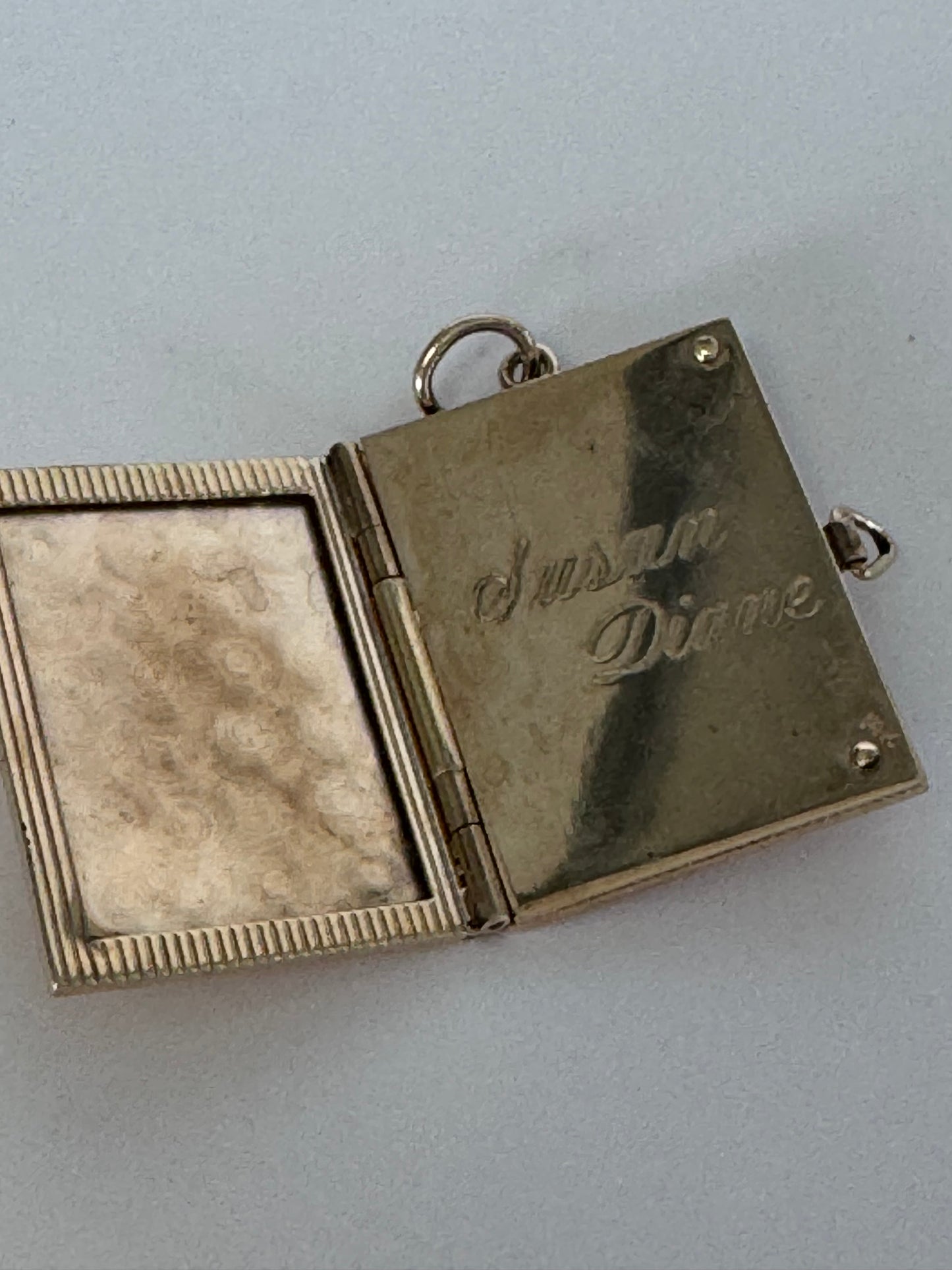 Vintage 14K gold book locket with hinged pages, engine-turned texture, engraved details, multiple photo compartments