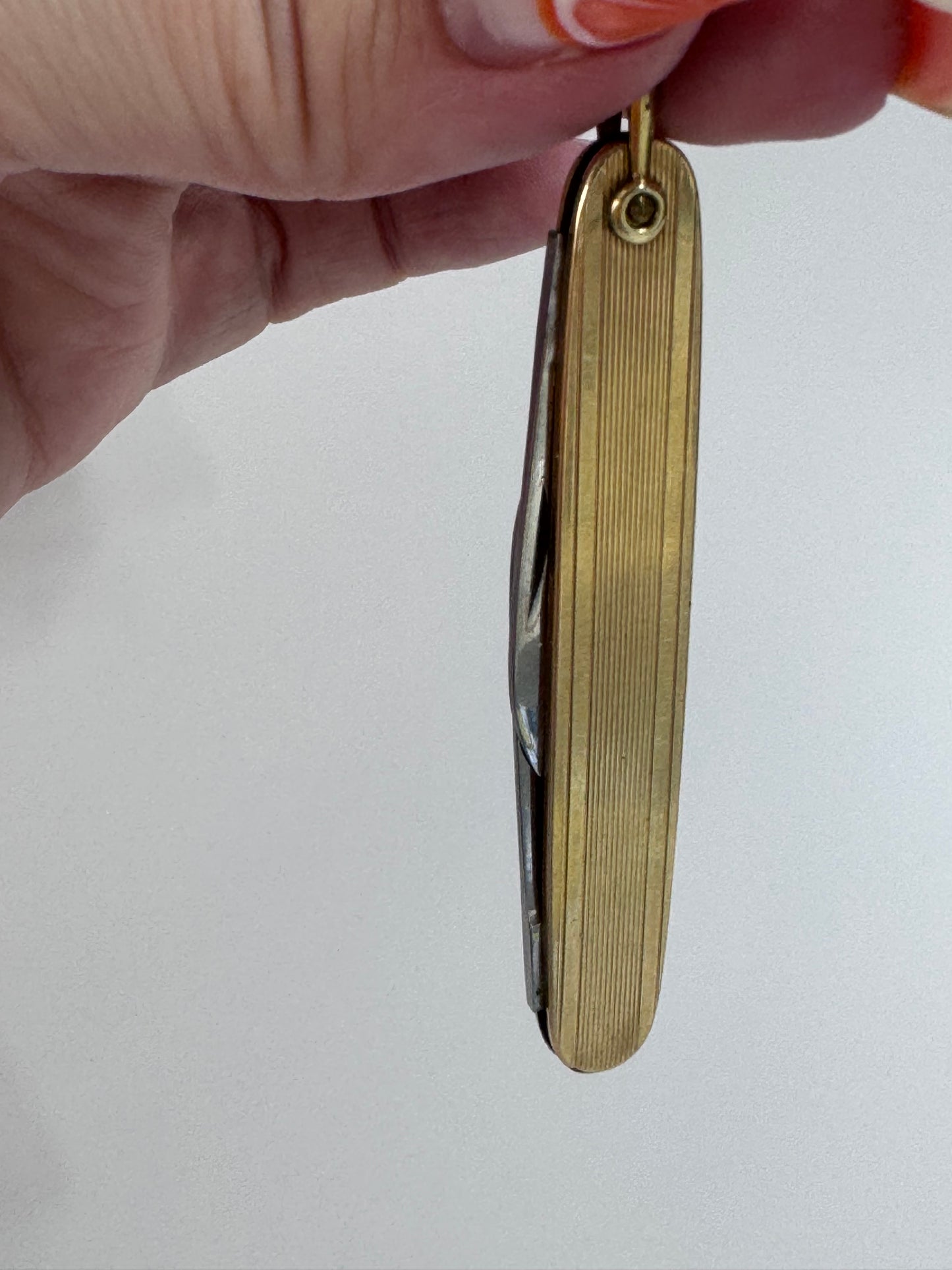 Vintage 10K gold pocket knife pendant with working steel blade, engine turned texture and engraved details, functional jewelry