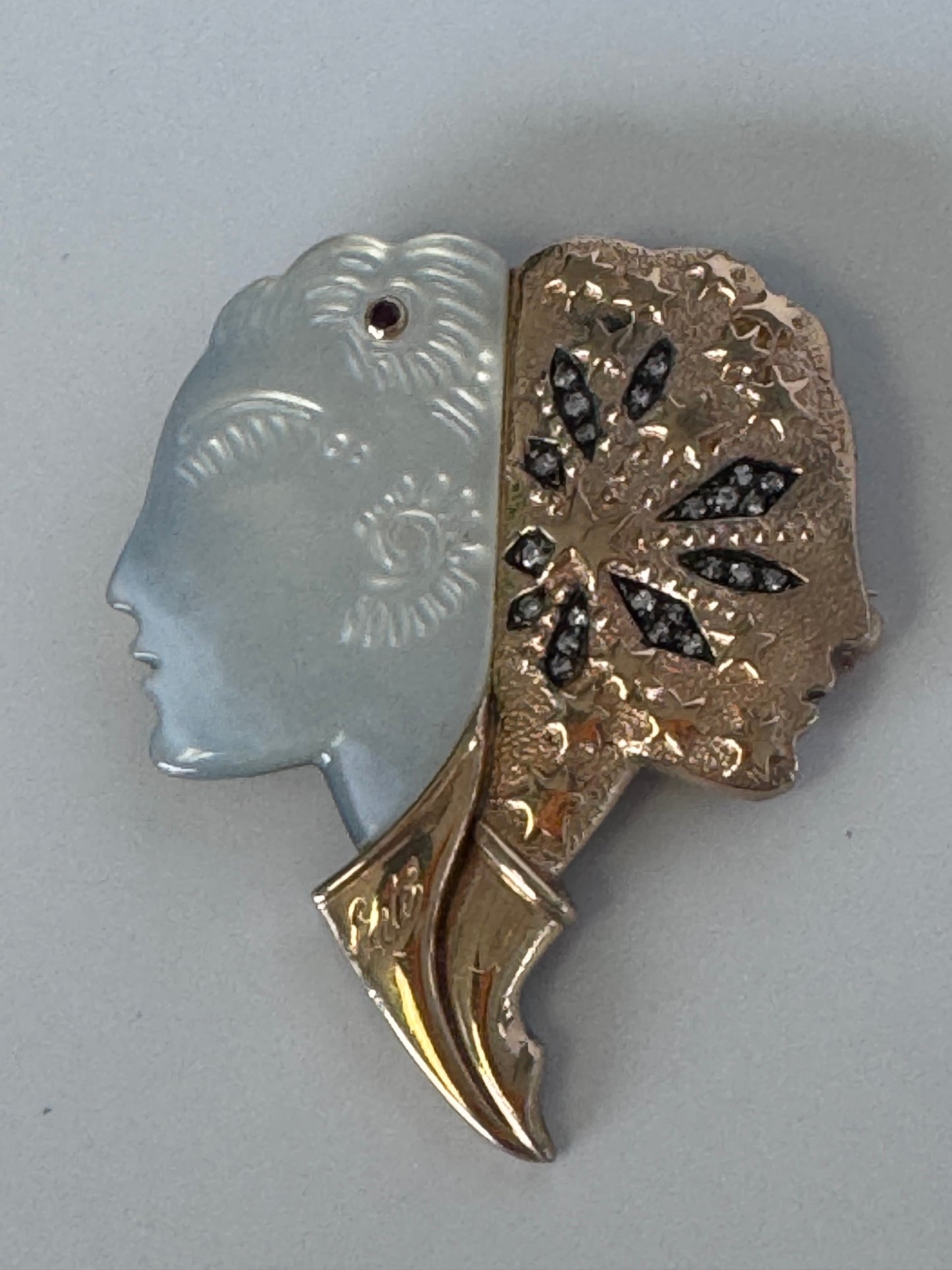 Erté Nuit et Jour brooch with carved mother of pearl dual profiles, sterling silver textured body, 14K gold diamond foliate accents