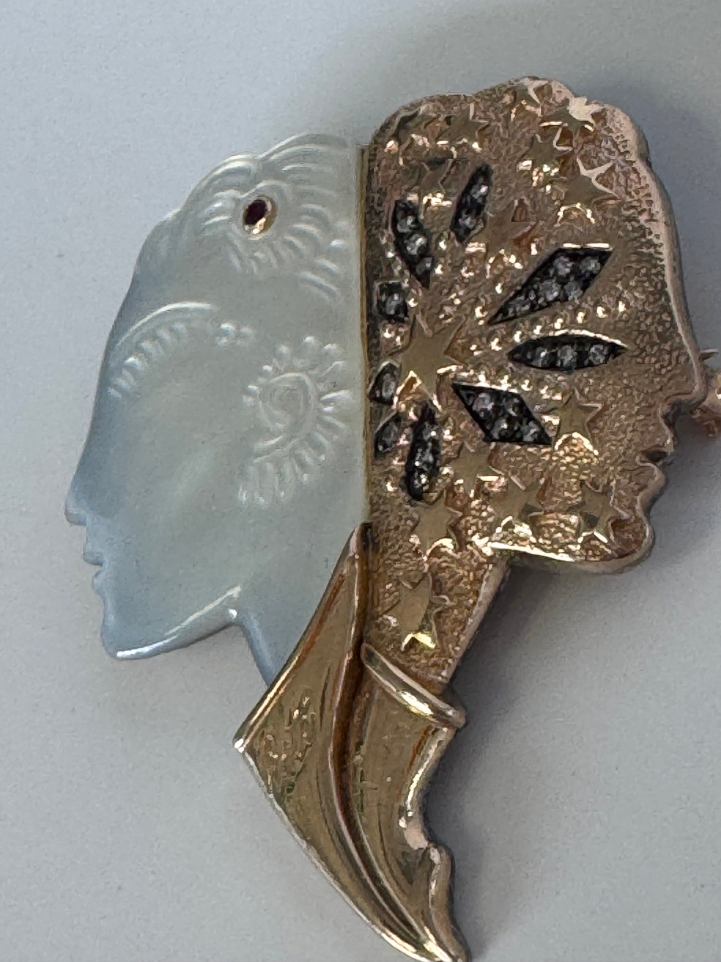 Erté Nuit et Jour brooch with carved mother of pearl dual profiles, sterling silver textured body, 14K gold diamond foliate accents