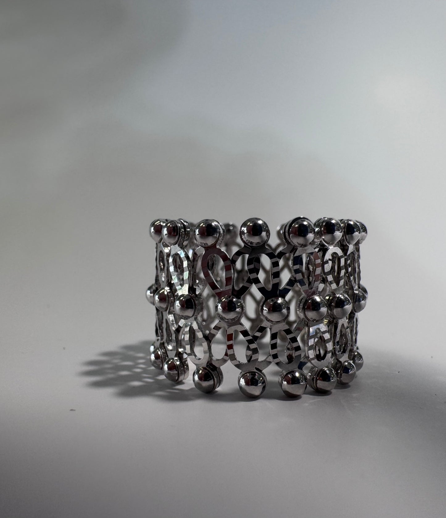 Silver beaded ring on a light gray background