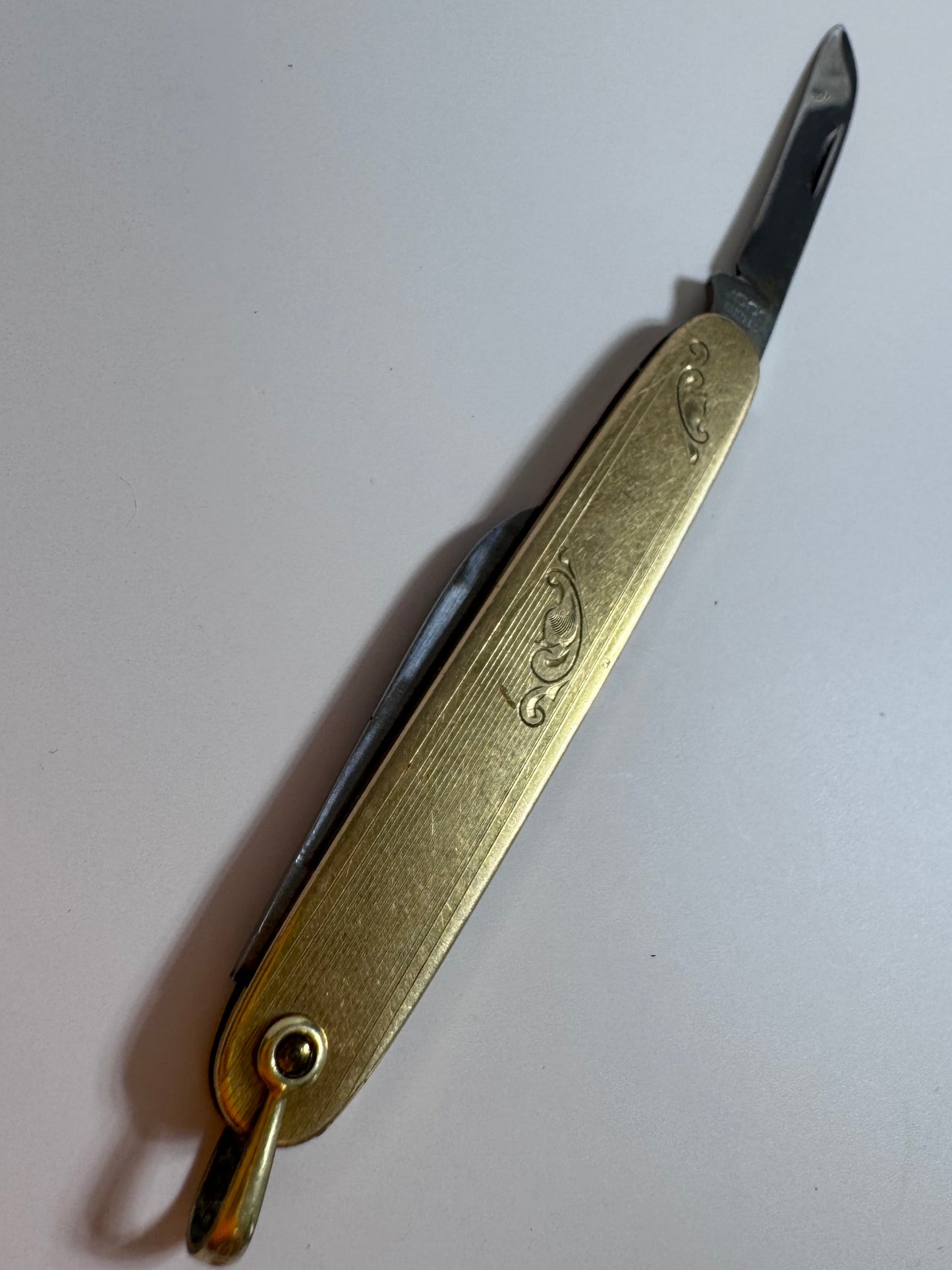 Vintage 10K gold pocket knife pendant with working steel blade, engine turned texture and engraved details, functional jewelry