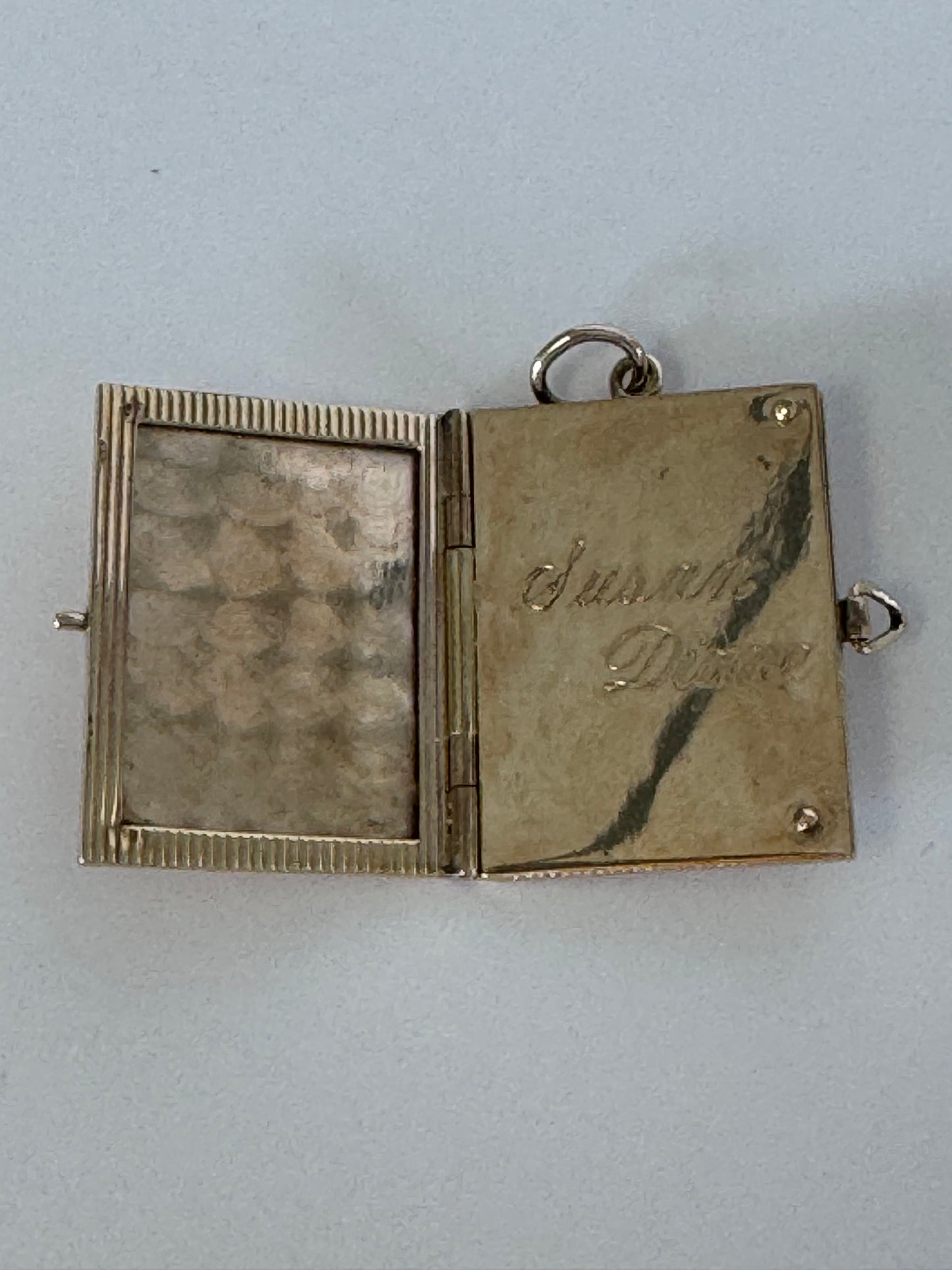 Vintage 14K gold book locket with hinged pages, engine-turned texture, engraved details, multiple photo compartments