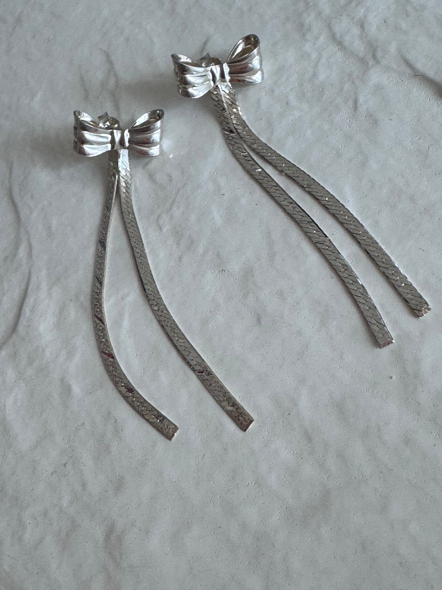 Estate 1980s sterling silver bow drop earrings with textured dangles measuring approximately 2.5 inches long showing dramatic vintage design