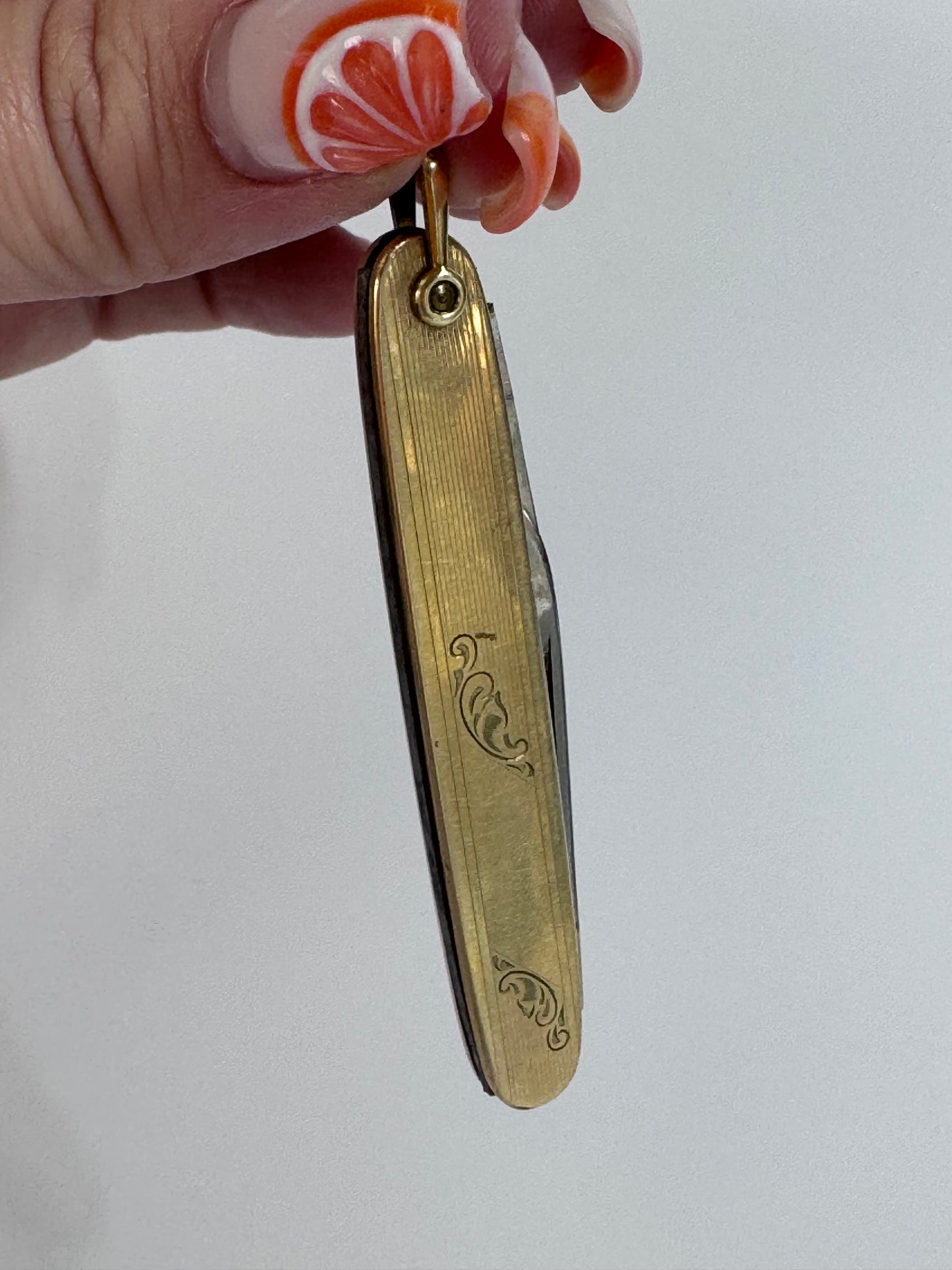 Vintage 10K gold pocket knife pendant with working steel blade, engine turned texture and engraved details, functional jewelry