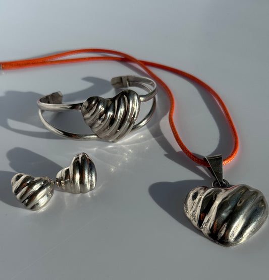 Sterling silver puffy heart jewelry set including cuff bracelet, stud earrings, and pendant with orange cord