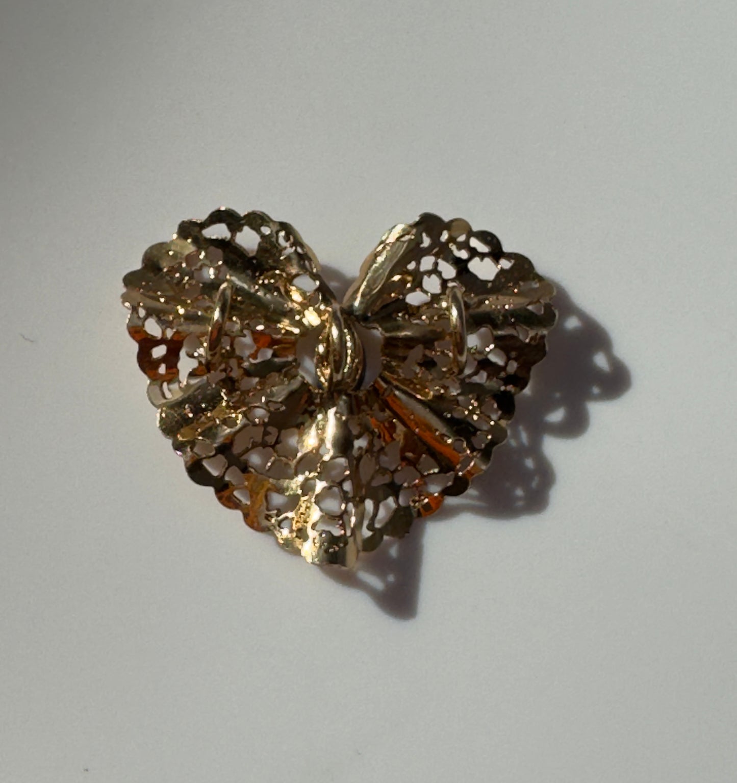 Estate 1980s 14K yellow gold heart slide pendant with blue sapphire centerstone and intricate pierced filigree openwork design