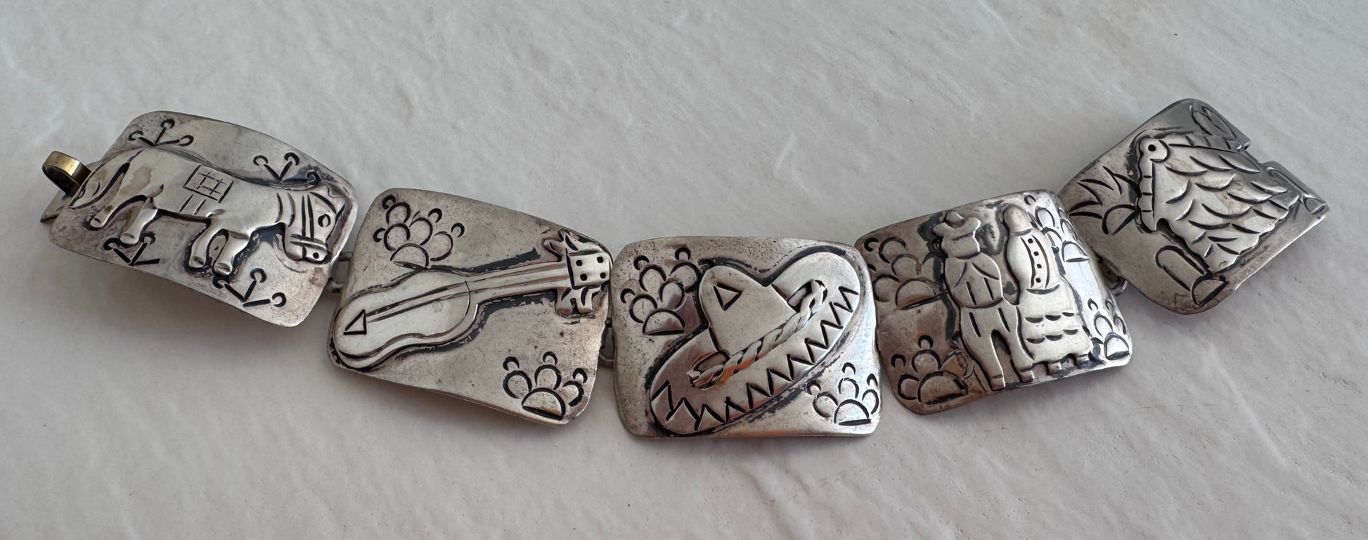 Estate J. Alvarez Taxco Mexican sterling silver storyteller panel bracelet showing detailed cultural scenes with guitar player, pottery, and folk motifs