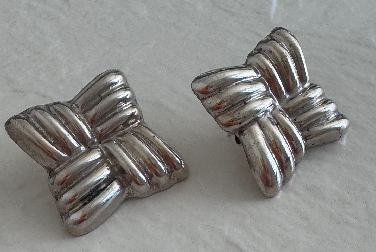 Estate Taxco Mexican sterling silver large puffy ribbon bow earrings with T925 Mexico hallmarks, showing dimensional ridged design