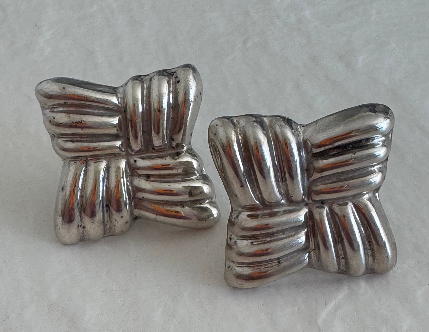 Estate Taxco Mexican sterling silver large puffy ribbon bow earrings with T925 Mexico hallmarks, showing dimensional ridged design