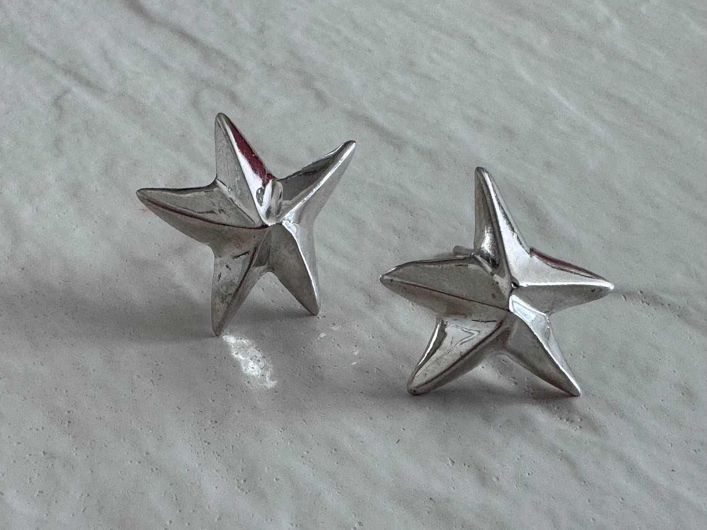 Estate sterling silver dimensional puffy star stud earrings with mirror finish, approximately half inch, showing quality construction