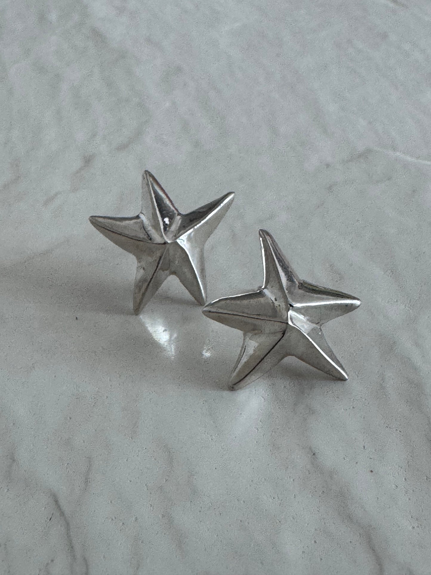Estate sterling silver dimensional puffy star stud earrings with mirror finish, approximately half inch, showing quality construction