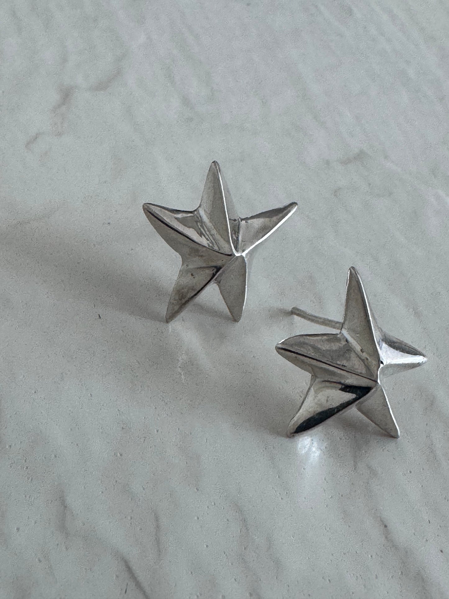 Estate sterling silver dimensional puffy star stud earrings with mirror finish, approximately half inch, showing quality construction