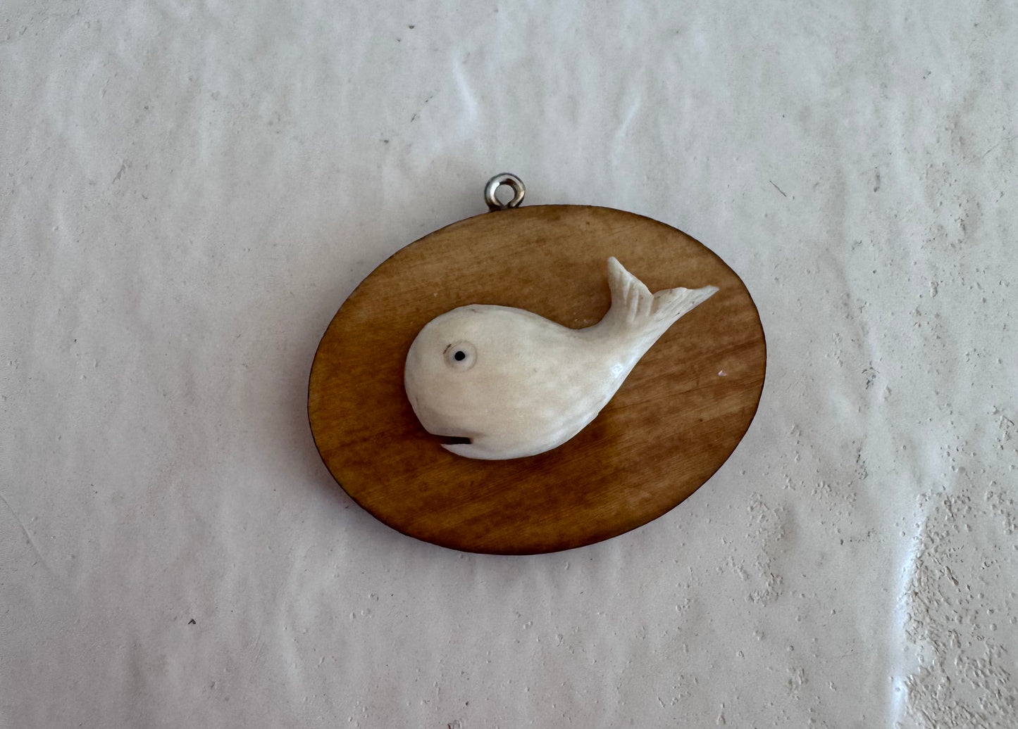 Vintage scrimshaw-style carved whale pendant on natural wood oval with sterling silver bail