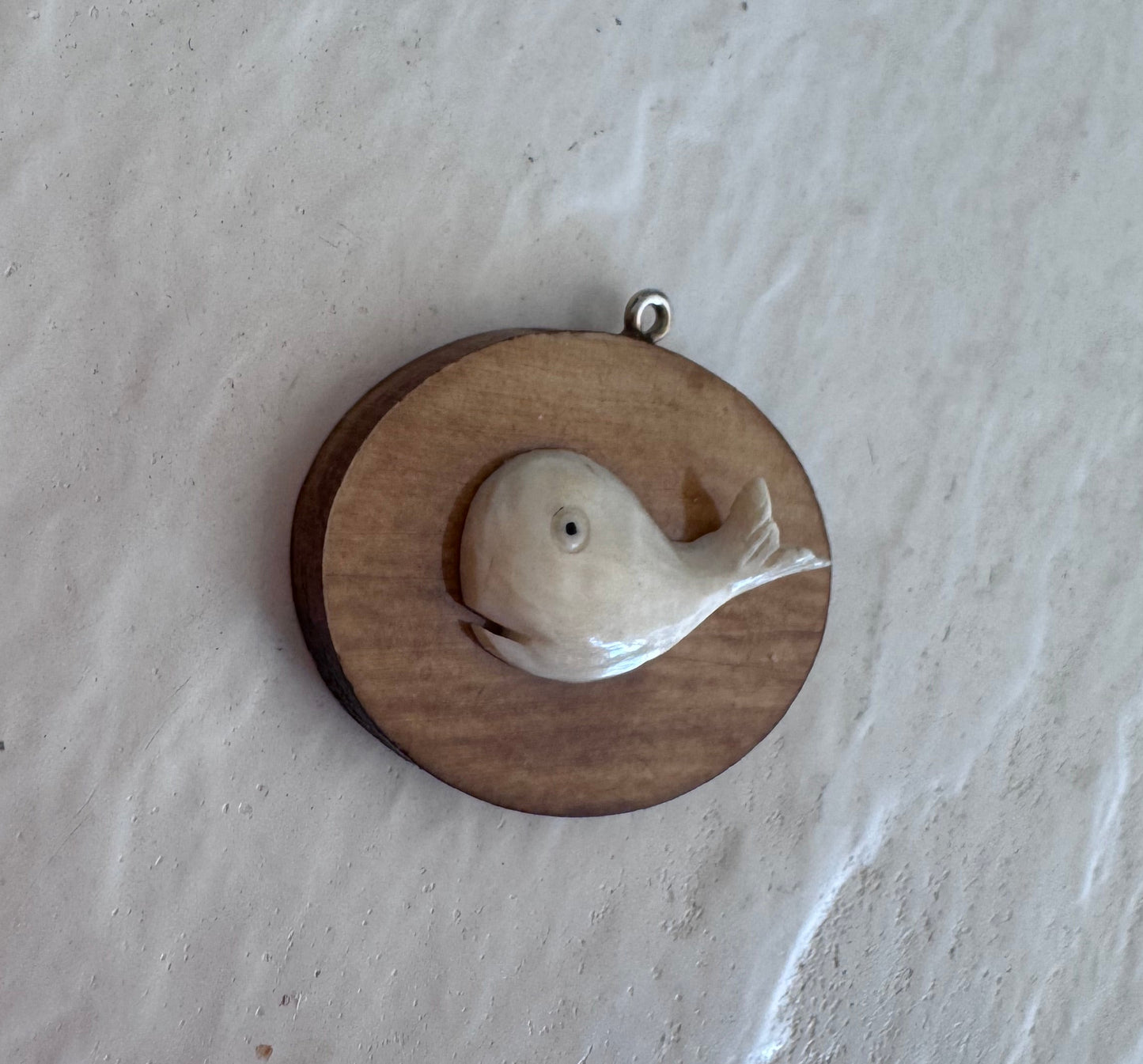 Vintage scrimshaw-style carved whale pendant on natural wood oval with sterling silver bail
