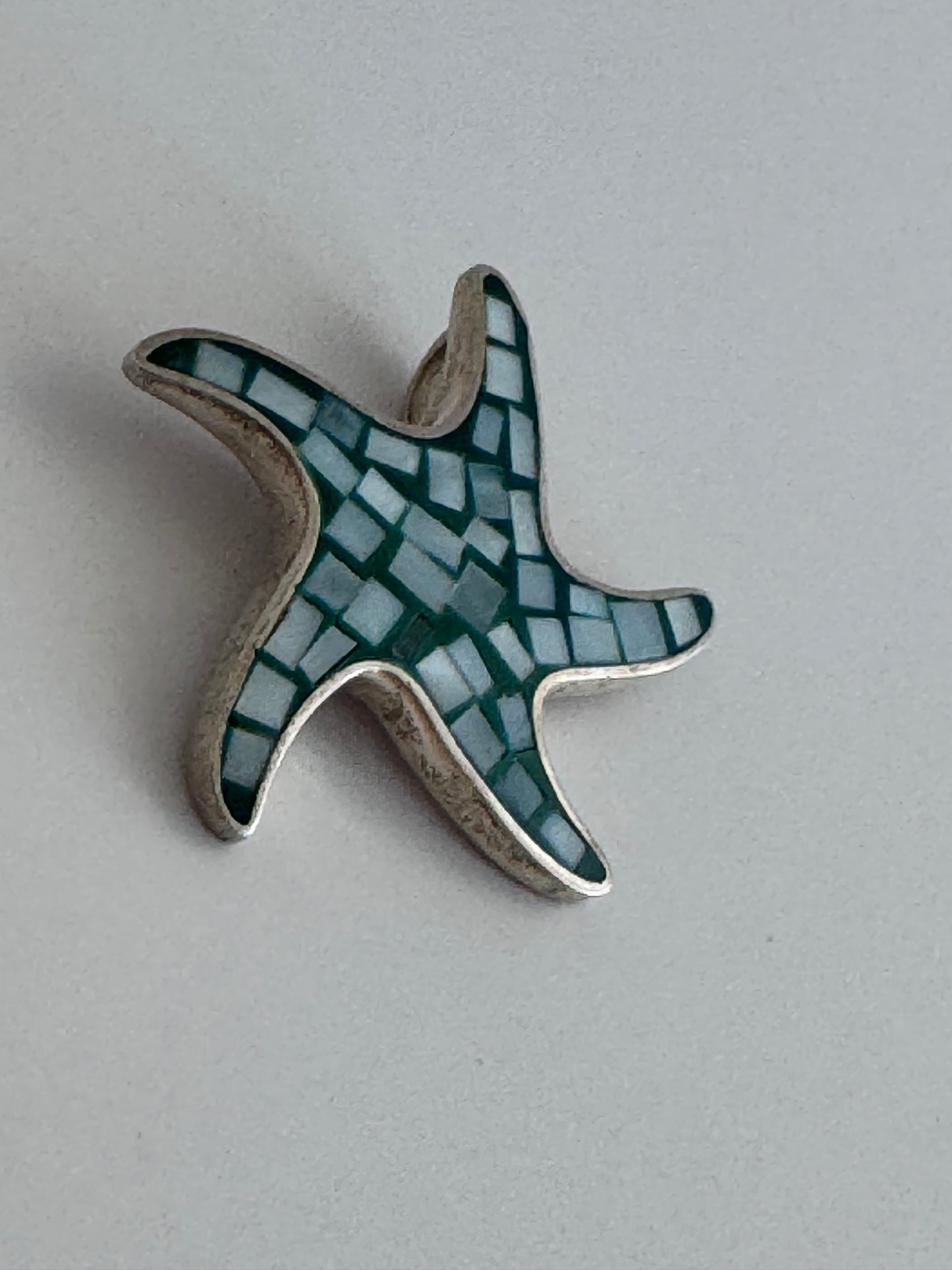 Vintage sterling silver starfish pendant with mother of pearl and green resin mosaic inlay, showing detailed craftsmanship and 925 hallmark