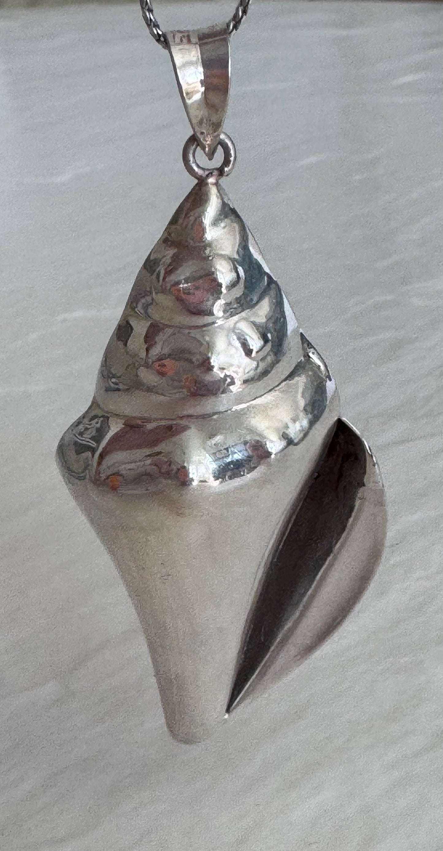 Large estate sterling silver conch shell pendant 2.75 inches long with hammered texture and included 14 inch chain, showing detailed spiral chambers