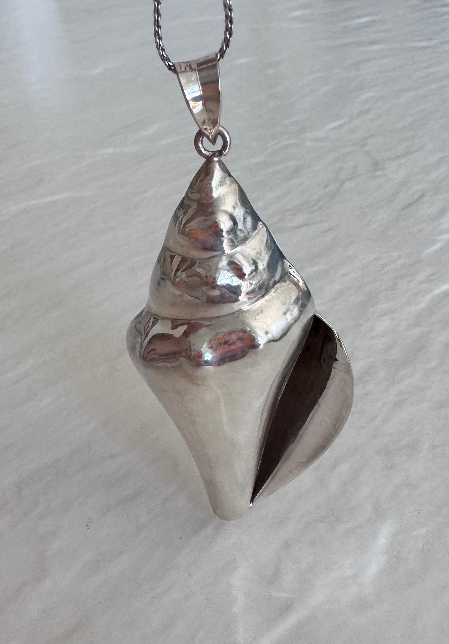 Large estate sterling silver conch shell pendant 2.75 inches long with hammered texture and included 14 inch chain, showing detailed spiral chambers