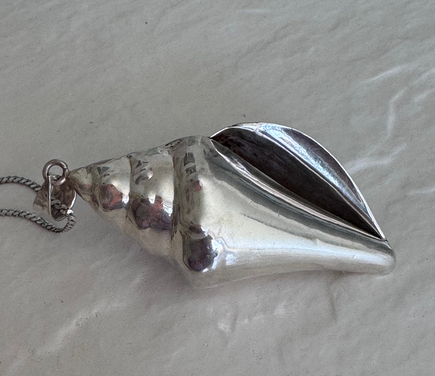 Large estate sterling silver conch shell pendant 2.75 inches long with hammered texture and included 14 inch chain, showing detailed spiral chambers