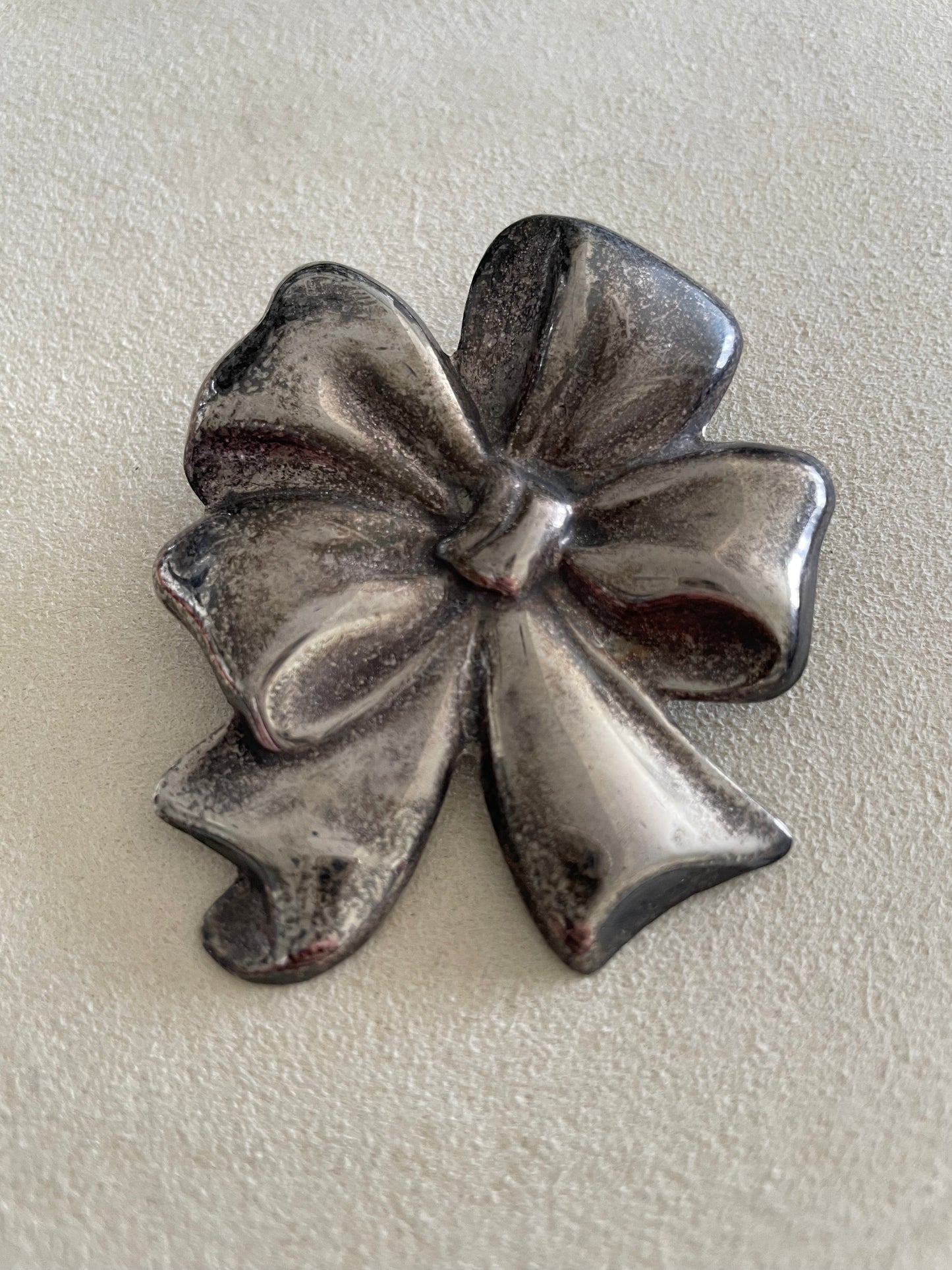 Large estate Mexican sterling silver puffy bow brooch pin pendant with mirror finish, displayed on pink cord necklace