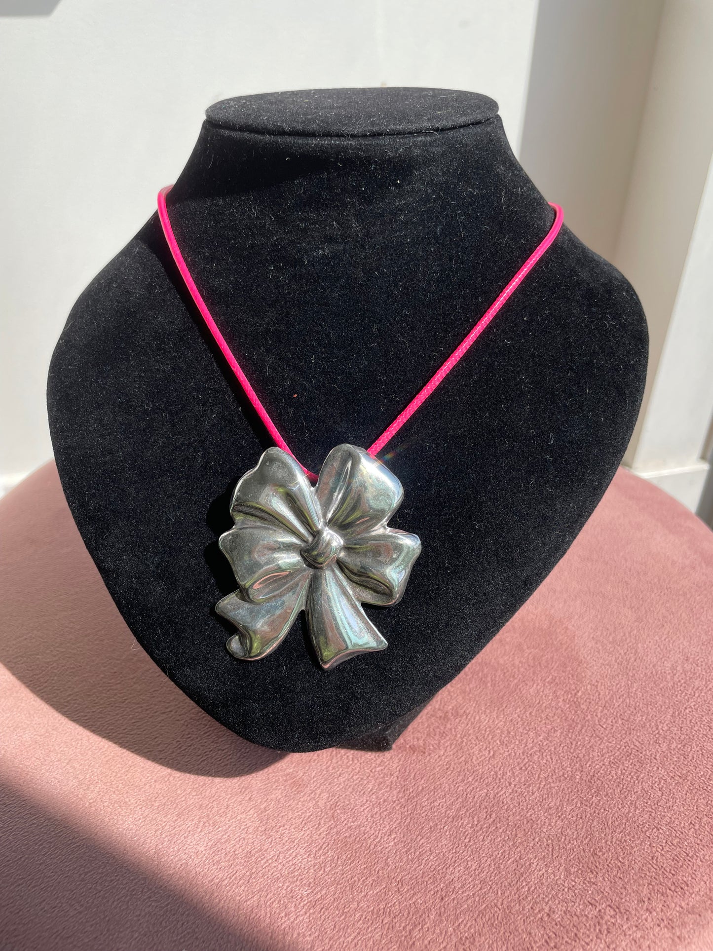 Large estate Mexican sterling silver puffy bow brooch pin pendant with mirror finish, displayed on pink cord necklace