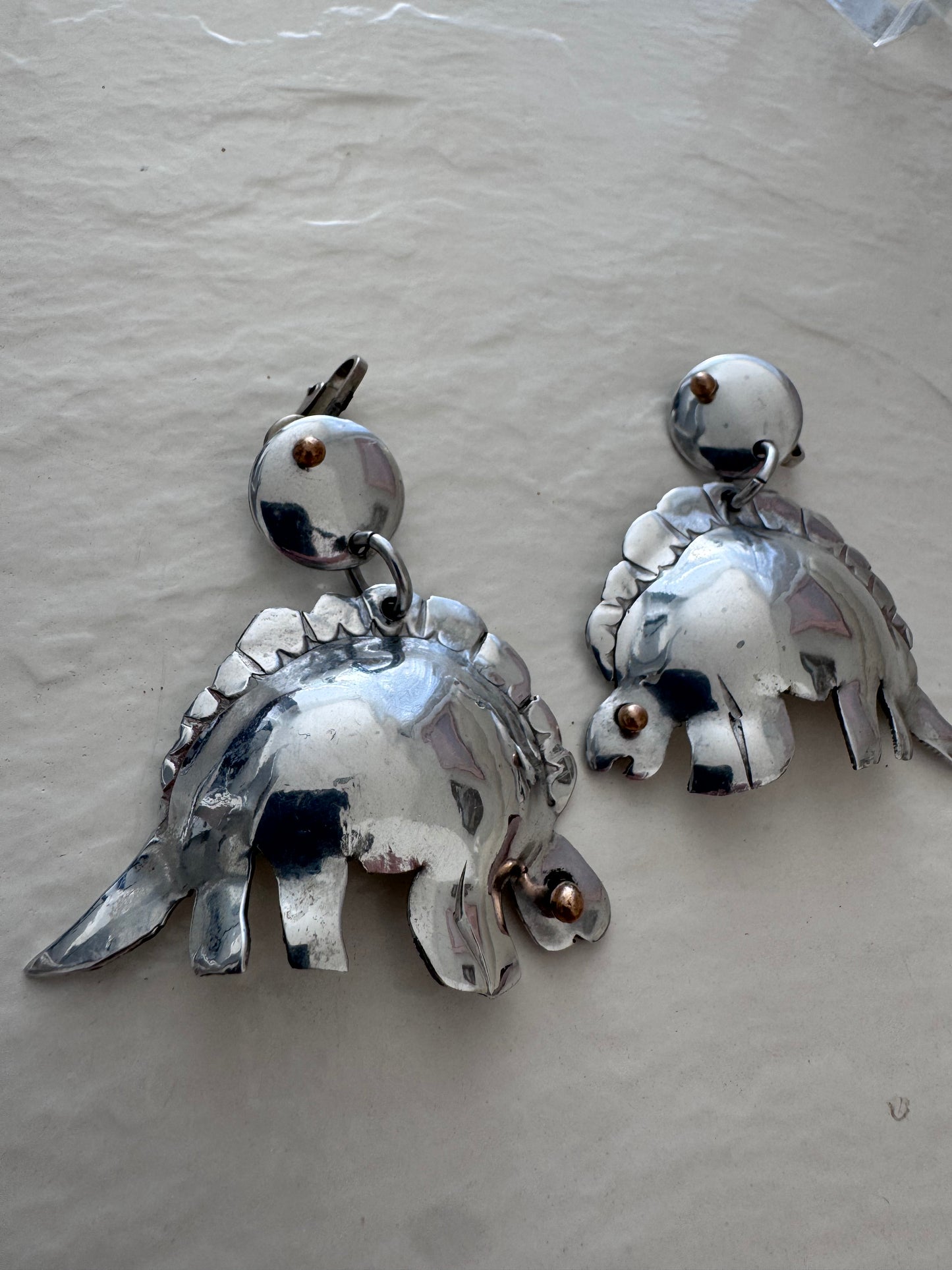 Large vintage silver stegosaurus dinosaur statement dangle clip-on earrings with gold-tone accents, handmade oversized hollow-form construction