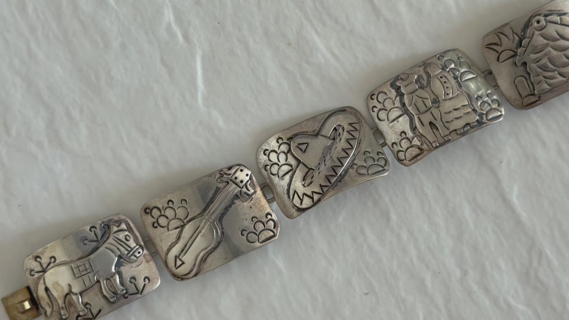 Estate J. Alvarez Taxco Mexican sterling silver storyteller panel bracelet showing detailed cultural scenes with guitar player, pottery, and folk motifs