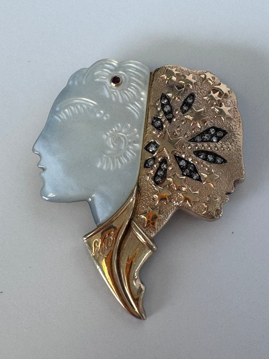 Erté Nuit et Jour brooch with carved mother of pearl dual profiles, sterling silver textured body, 14K gold diamond foliate accents