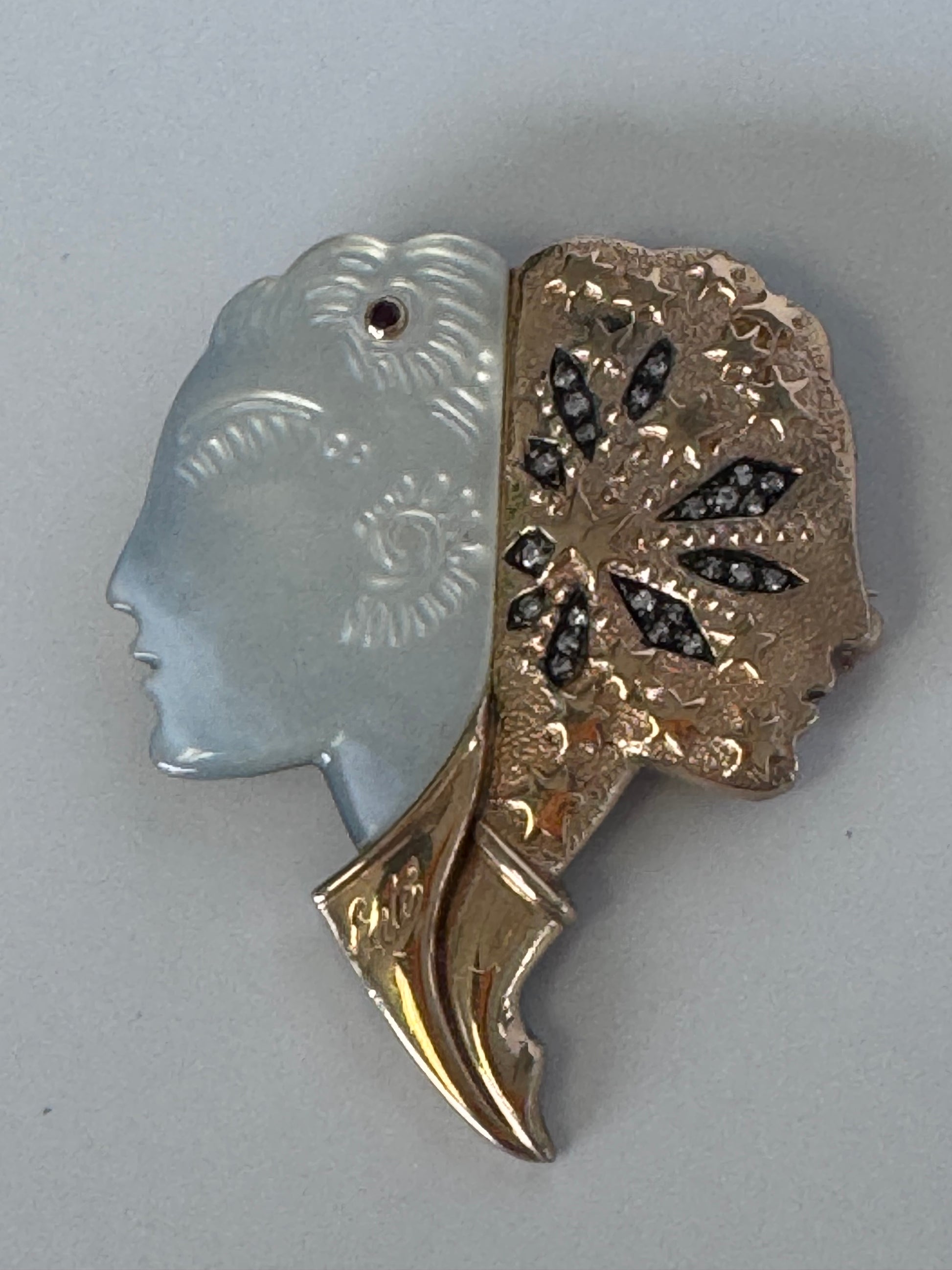 Erté Nuit et Jour brooch with carved mother of pearl dual profiles, sterling silver textured body, 14K gold diamond foliate accents