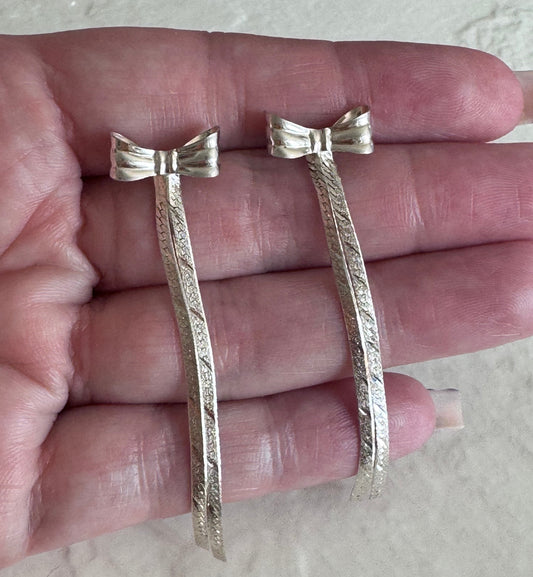 Estate 1980s sterling silver bow drop earrings with textured dangles measuring approximately 2.5 inches long showing dramatic vintage design

