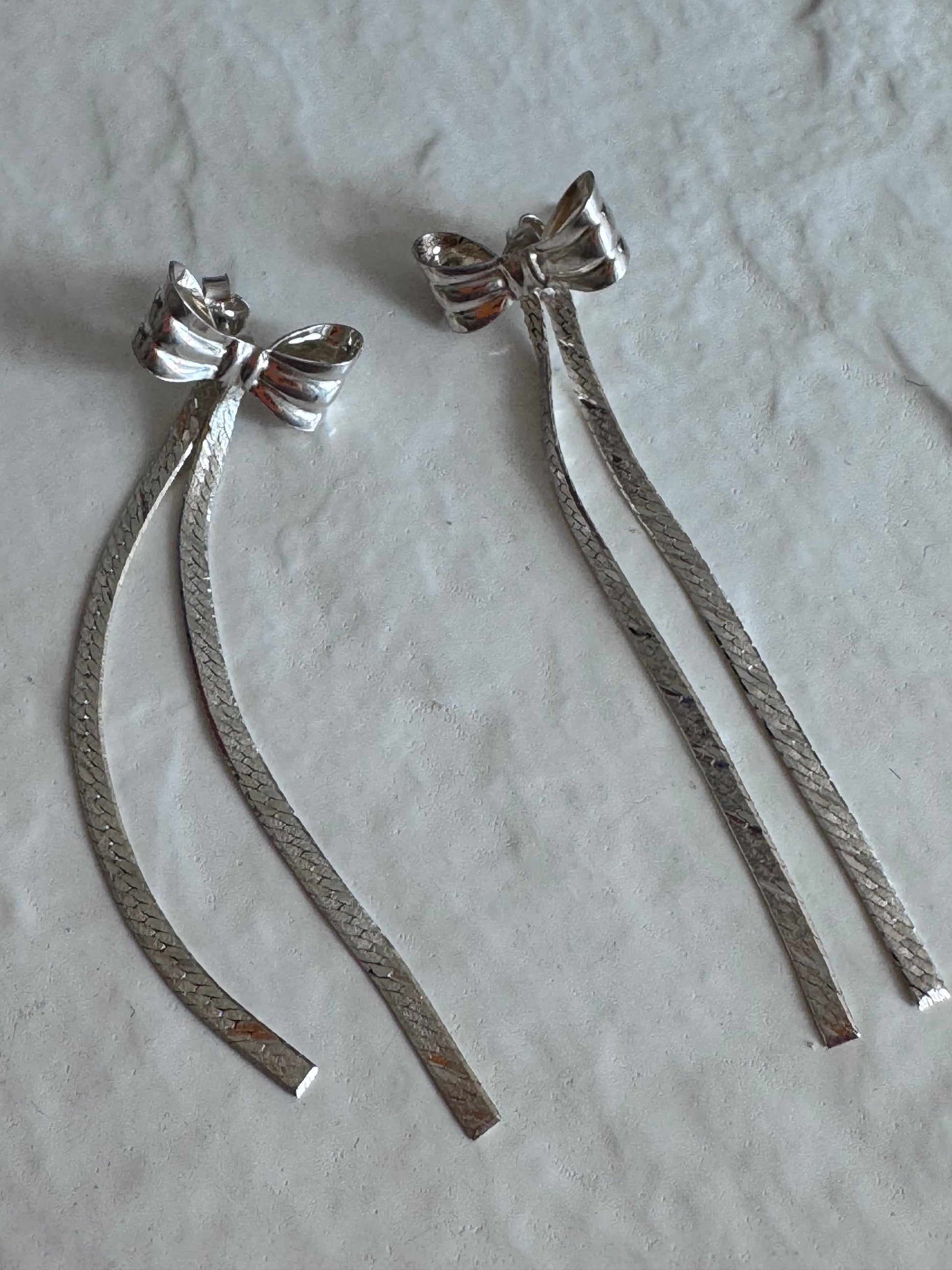 Estate 1980s sterling silver bow drop earrings with textured dangles measuring approximately 2.5 inches long showing dramatic vintage design
