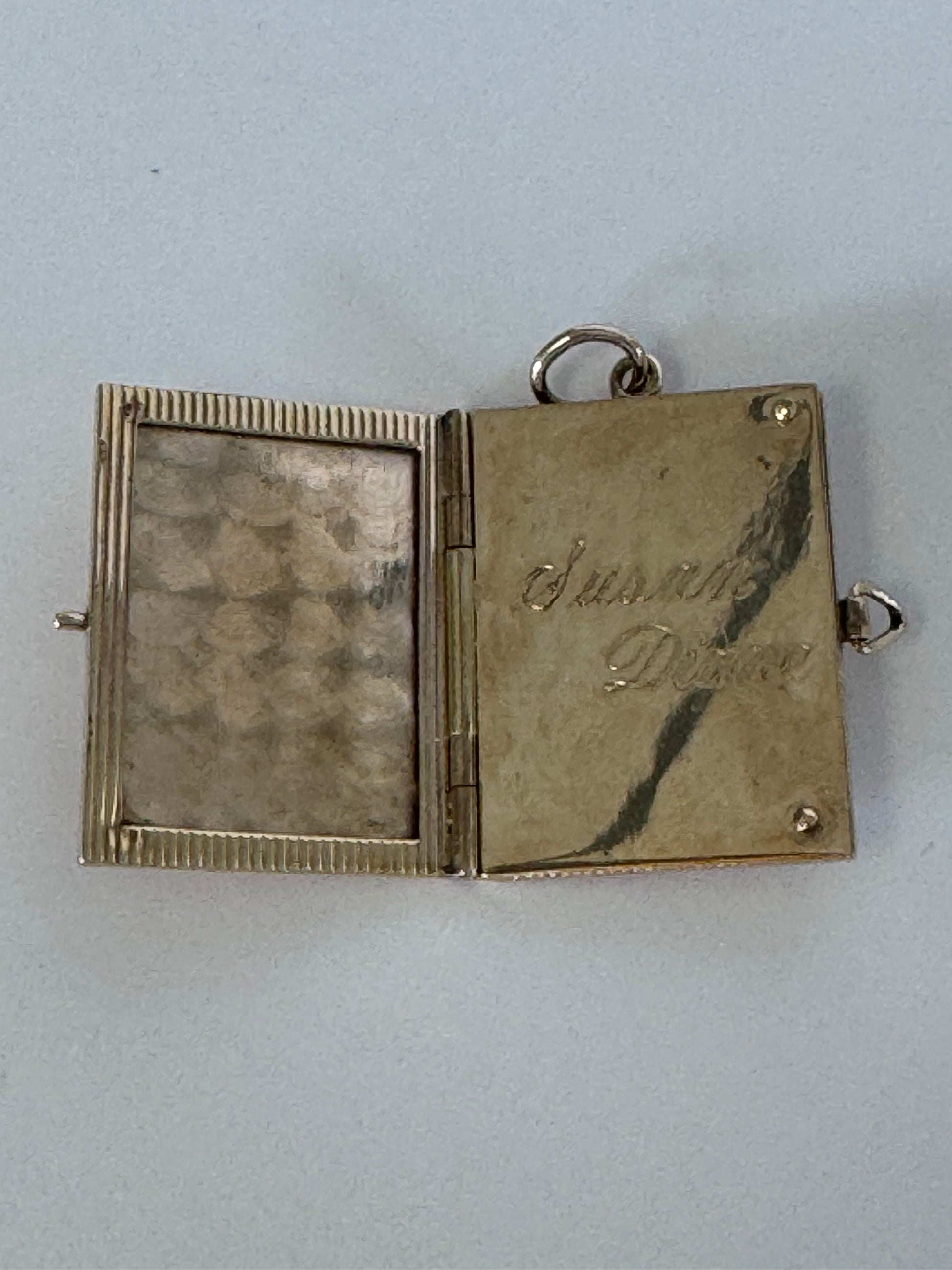 Vintage 14K gold book locket with hinged pages, engine-turned texture, engraved details, multiple photo compartments