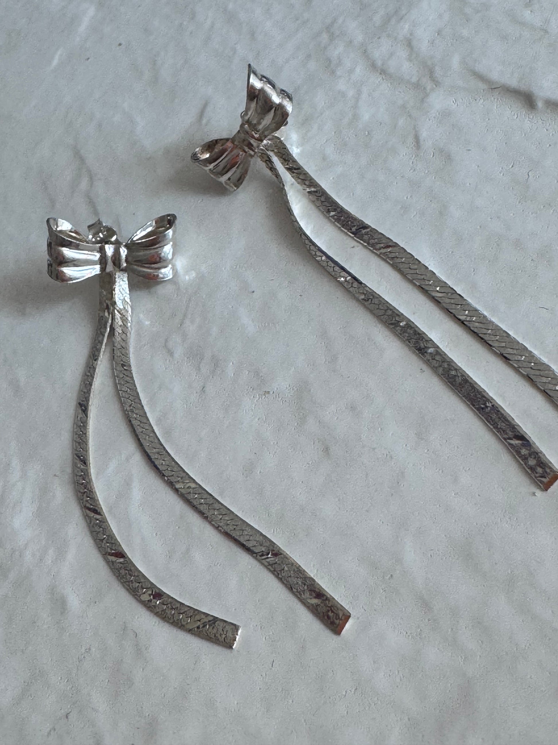 Estate 1980s sterling silver bow drop earrings with textured dangles measuring approximately 2.5 inches long showing dramatic vintage design

