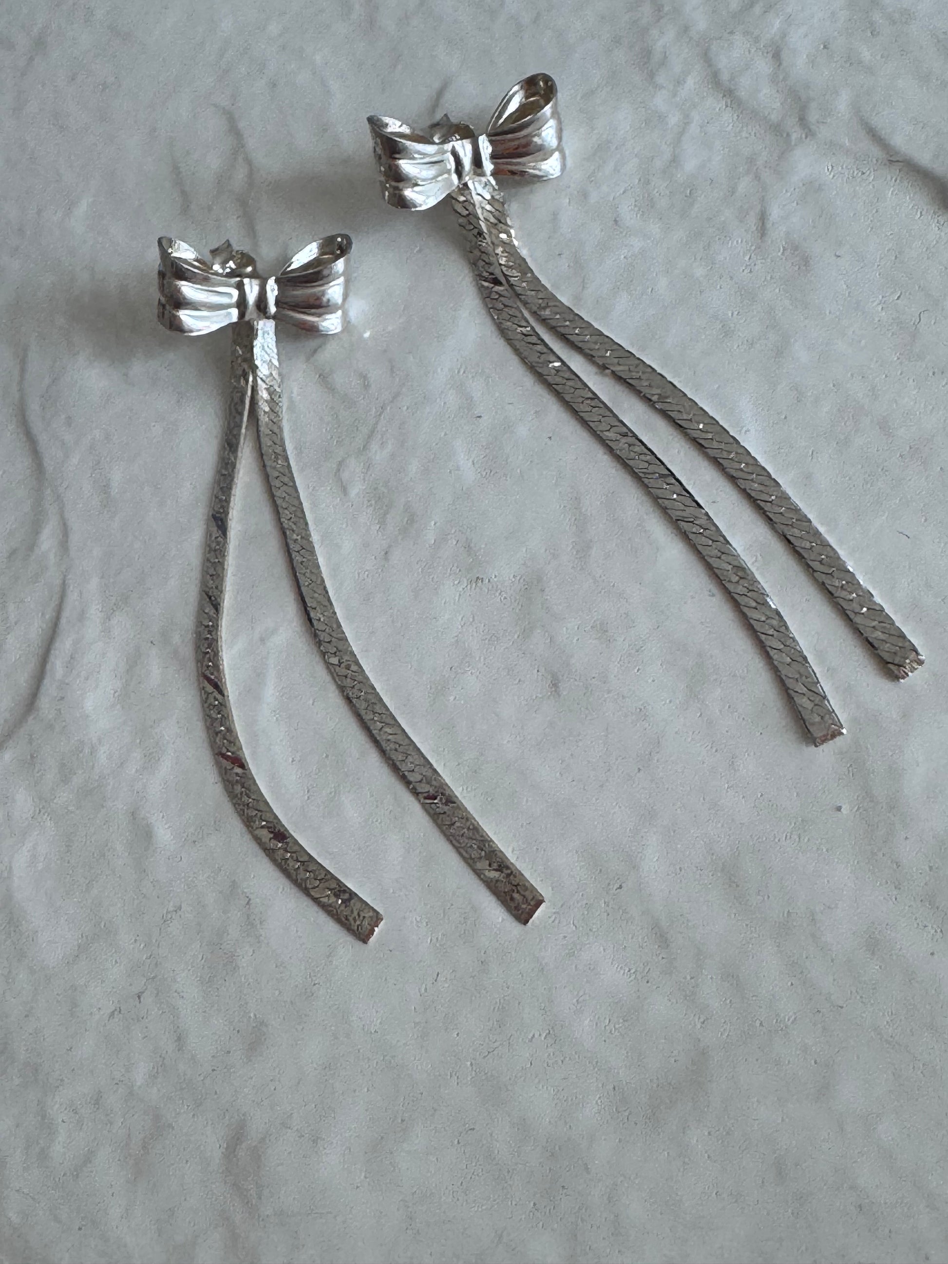 Estate 1980s sterling silver bow drop earrings with textured dangles measuring approximately 2.5 inches long showing dramatic vintage design
