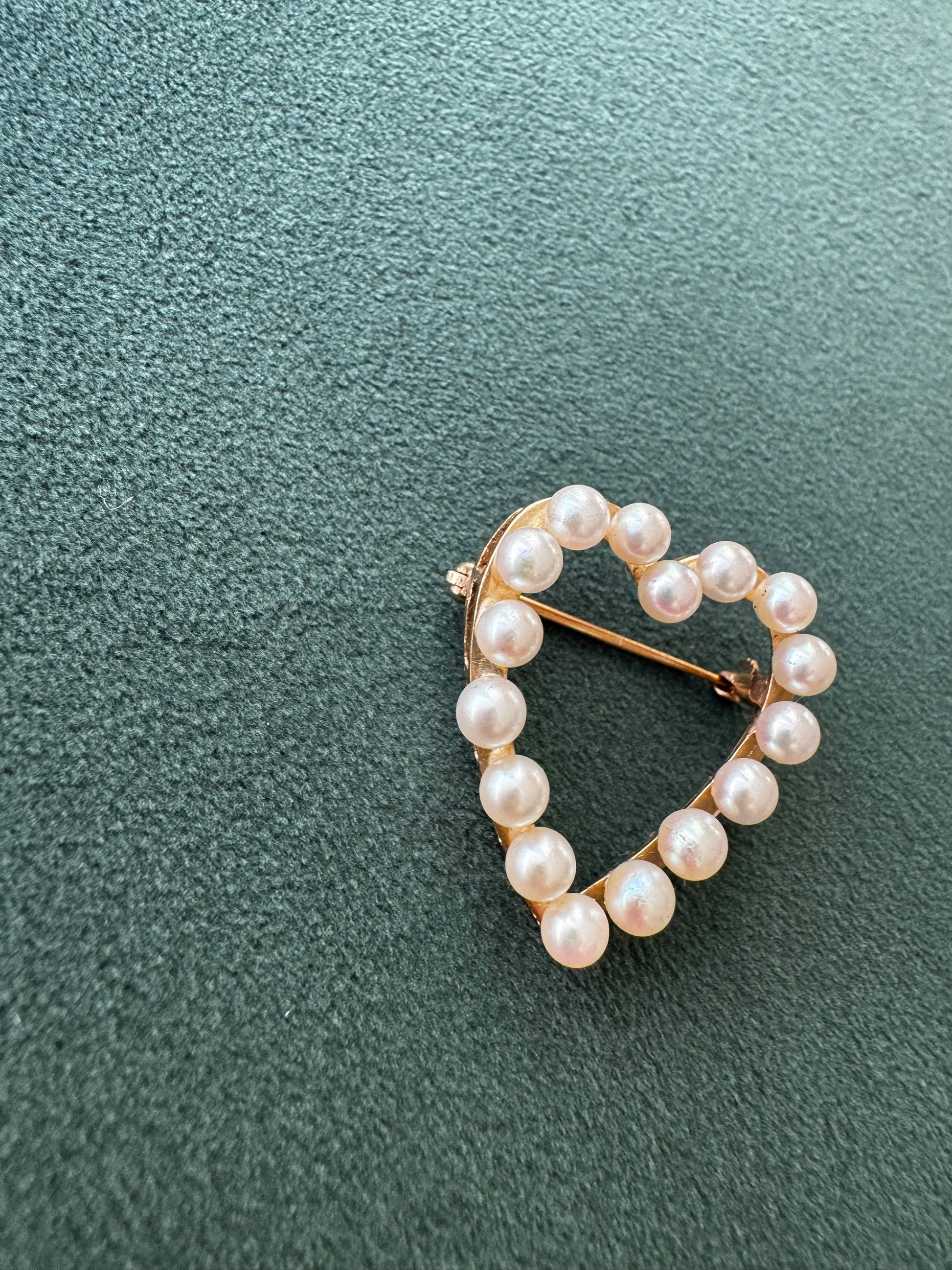 Pearl brooch on a textured green background
