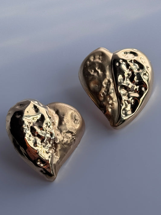 Estate vintage 14K yellow gold puffy heart stud earrings with textured repousse work showing shiny and matte contrast finishes