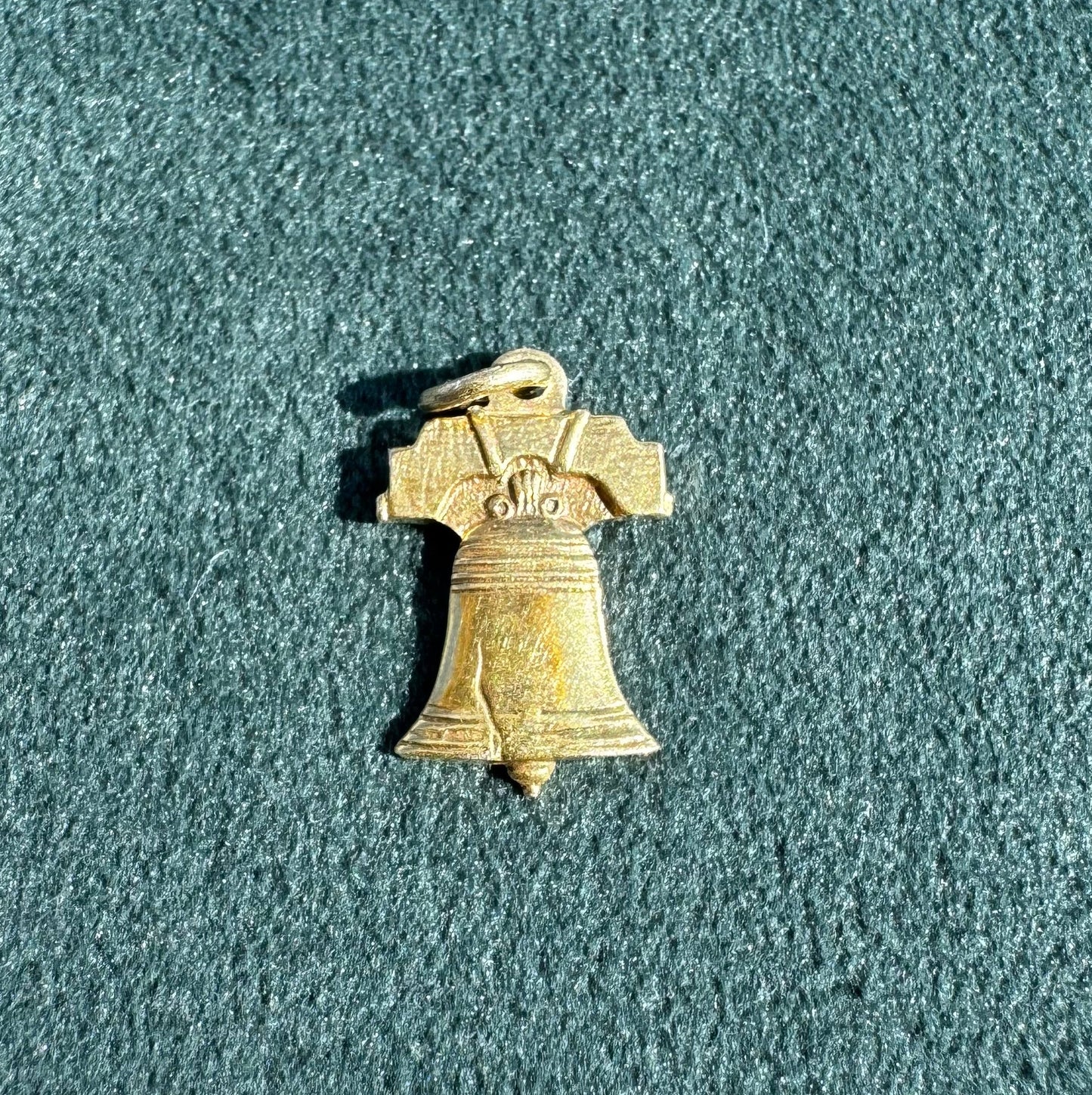 Small brass bell on a textured green surface