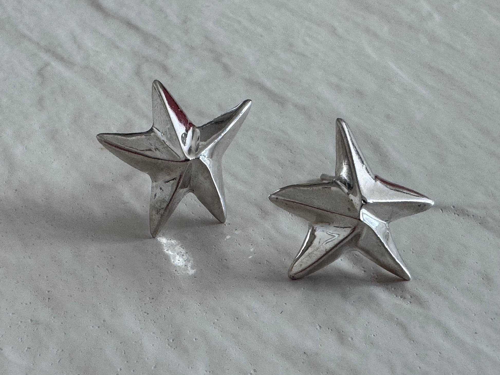 Estate sterling silver dimensional puffy star stud earrings with mirror finish, approximately half inch, showing quality construction