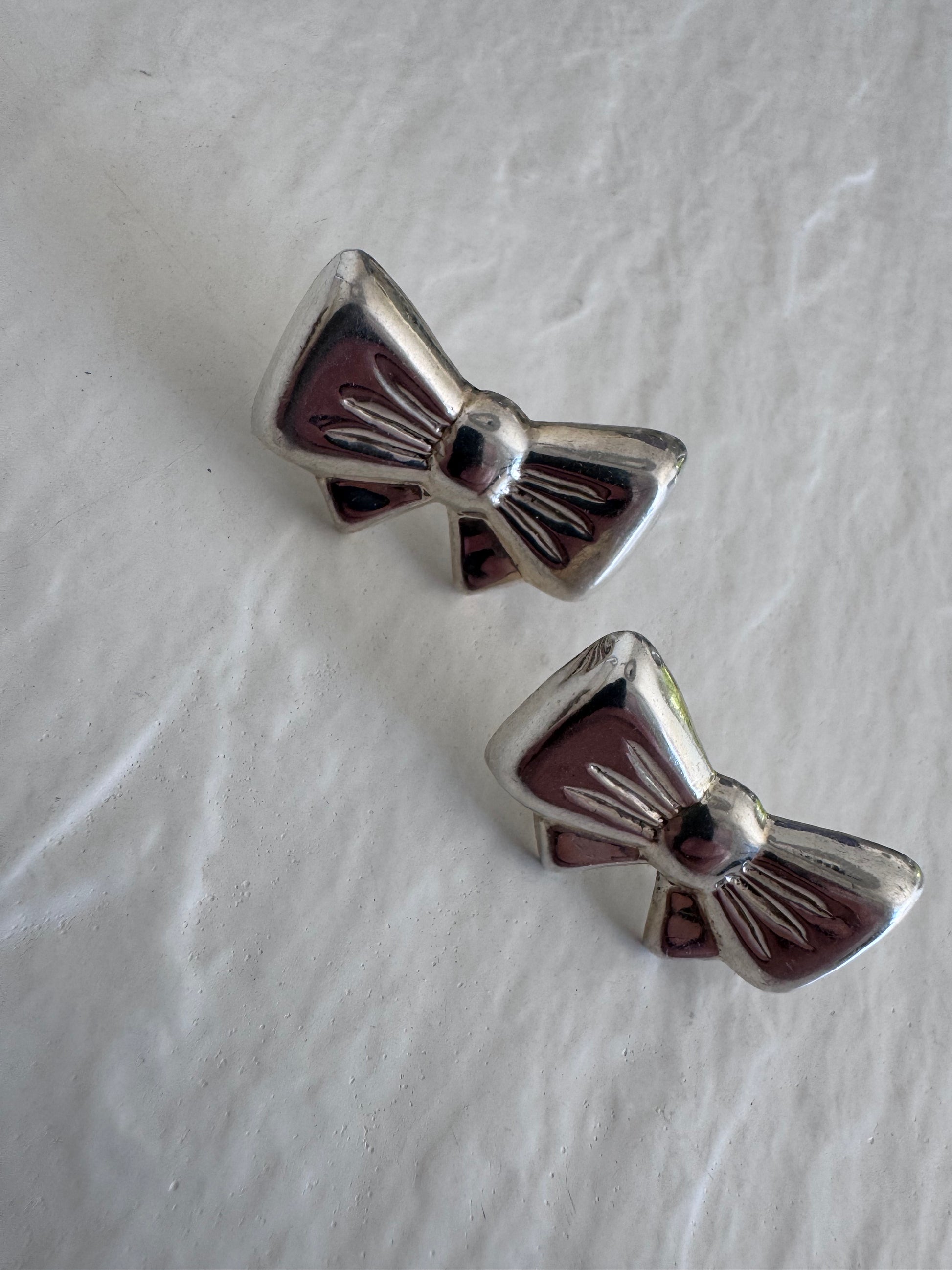 Vintage sterling silver bow earrings with detailed fabric texturing, 925 hallmark and mystery maker's mark, perfect for rockabilly pin-up style