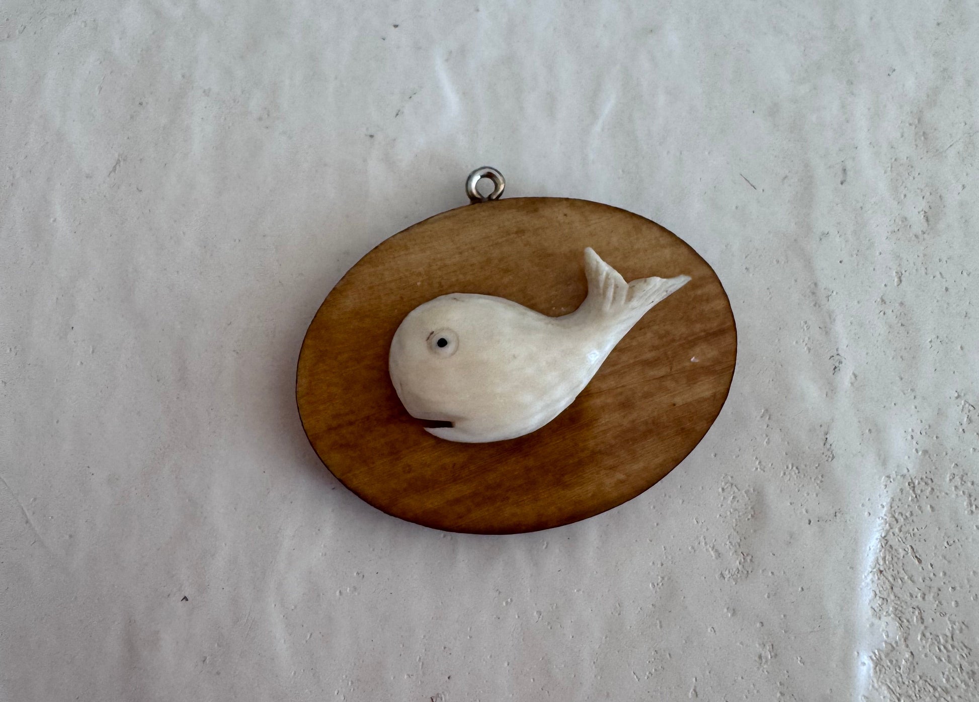 Vintage scrimshaw-style carved whale pendant on natural wood oval with sterling silver bail