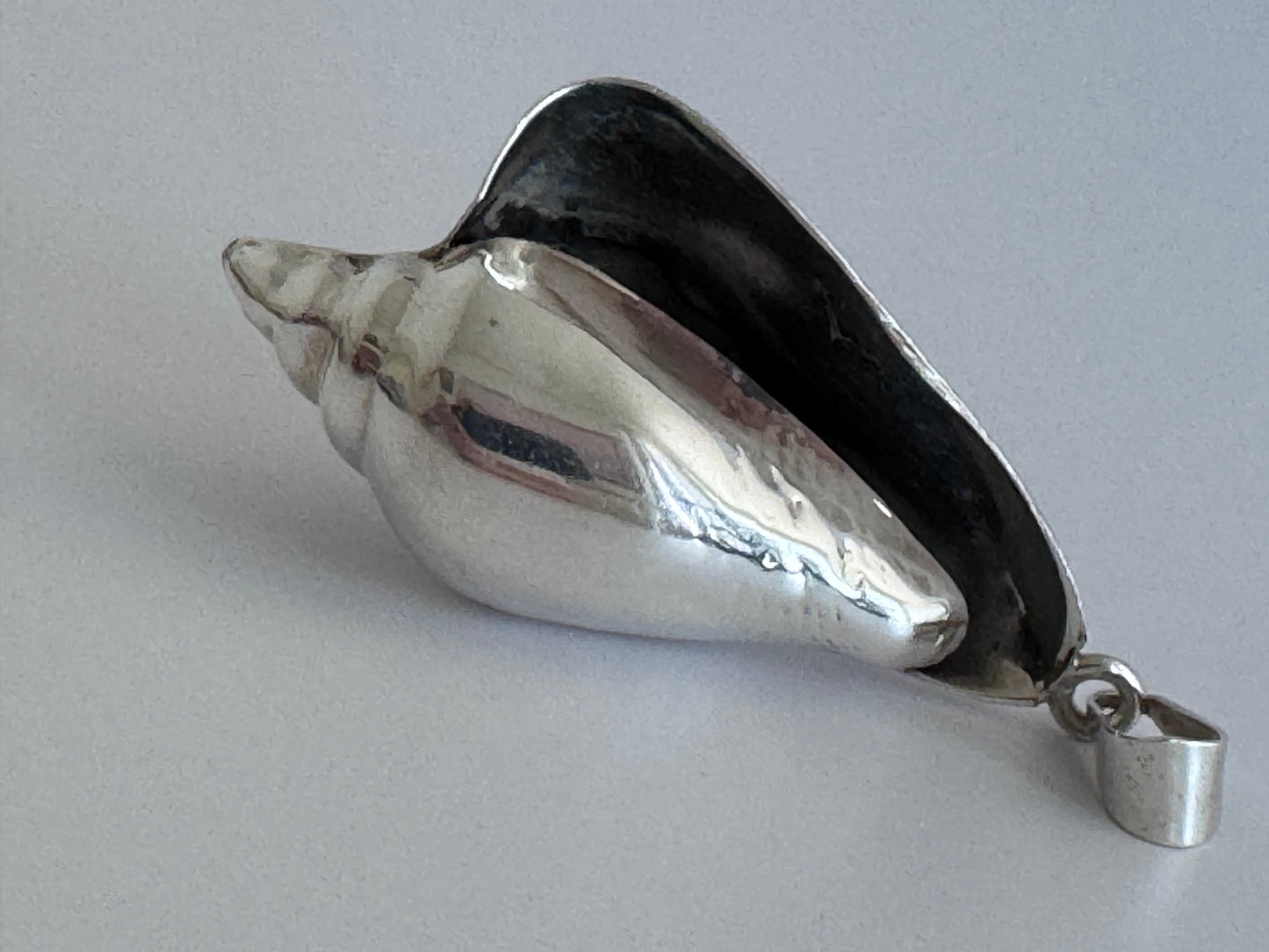 Large vintage sterling silver conch shell pendant with high-polish finish, showing detailed spiral shell design and secure bail