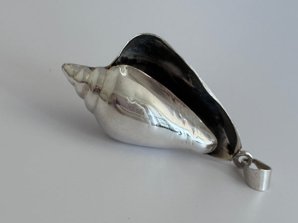 Large vintage sterling silver conch shell pendant with high-polish finish, showing detailed spiral shell design and secure bail