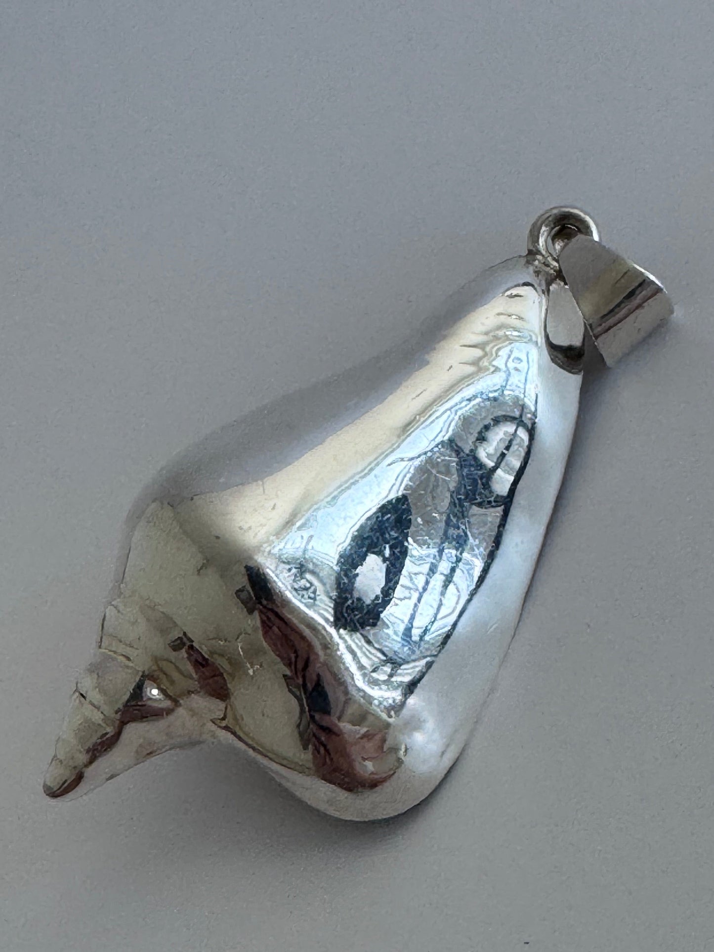 Large vintage sterling silver conch shell pendant with high-polish finish, showing detailed spiral shell design and secure bail
