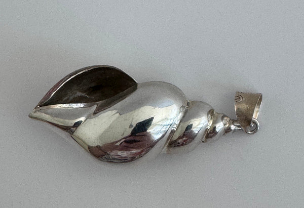 Large vintage sterling silver conch shell pendant with AI signature, showing detailed spiral shell design and high-polish finish