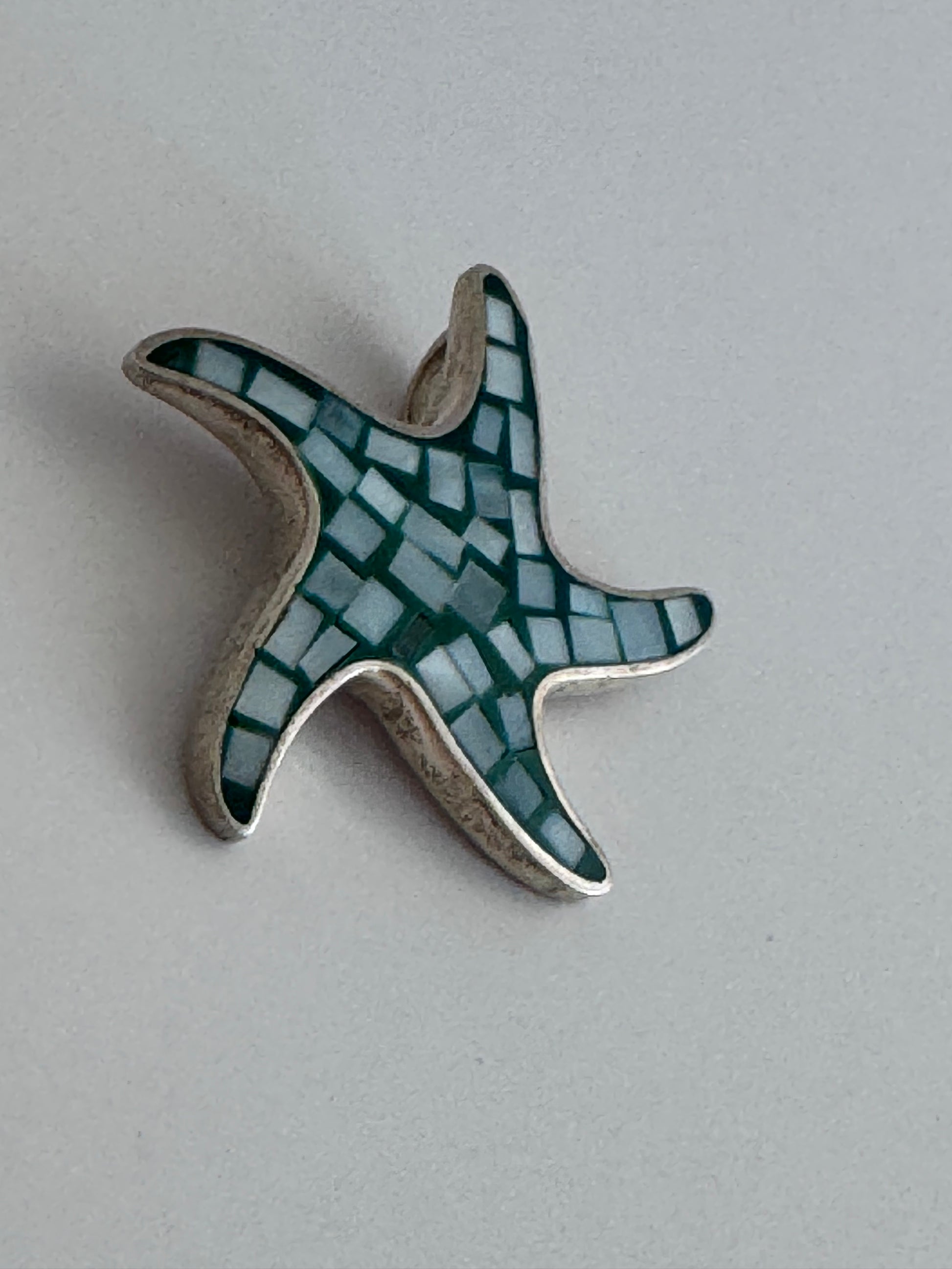Vintage sterling silver starfish pendant with mother of pearl and green resin mosaic inlay, showing detailed craftsmanship and 925 hallmark