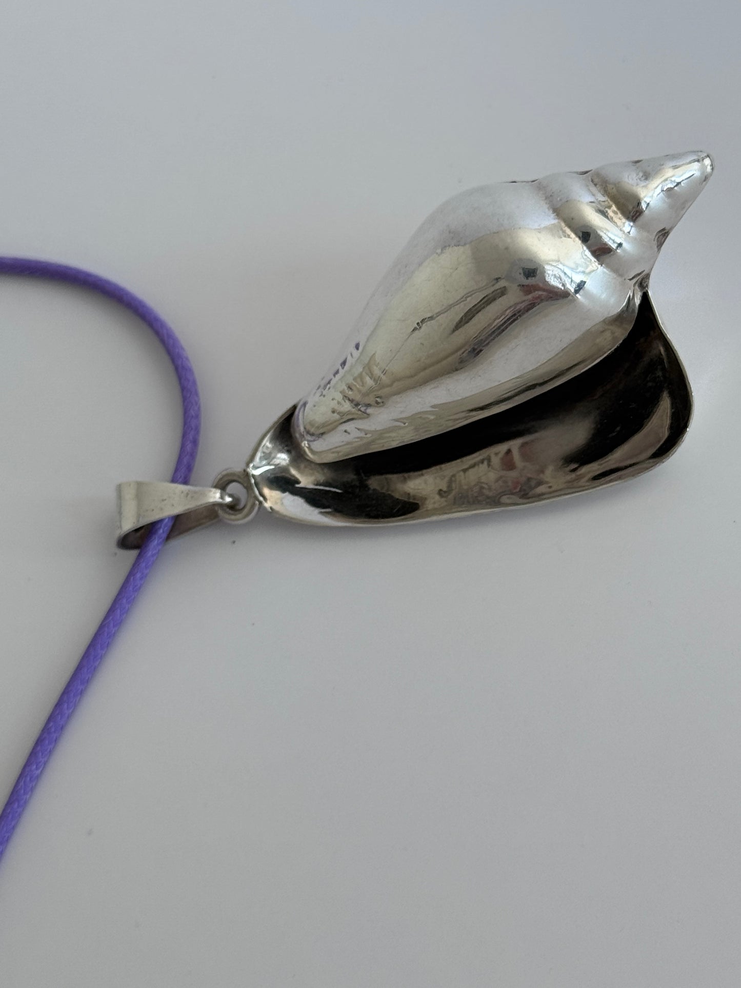 Large vintage sterling silver conch shell pendant with high-polish finish, showing detailed spiral shell design and secure bail