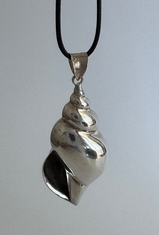 Large vintage sterling silver conch shell pendant with AI signature, showing detailed spiral shell design and high-polish finish