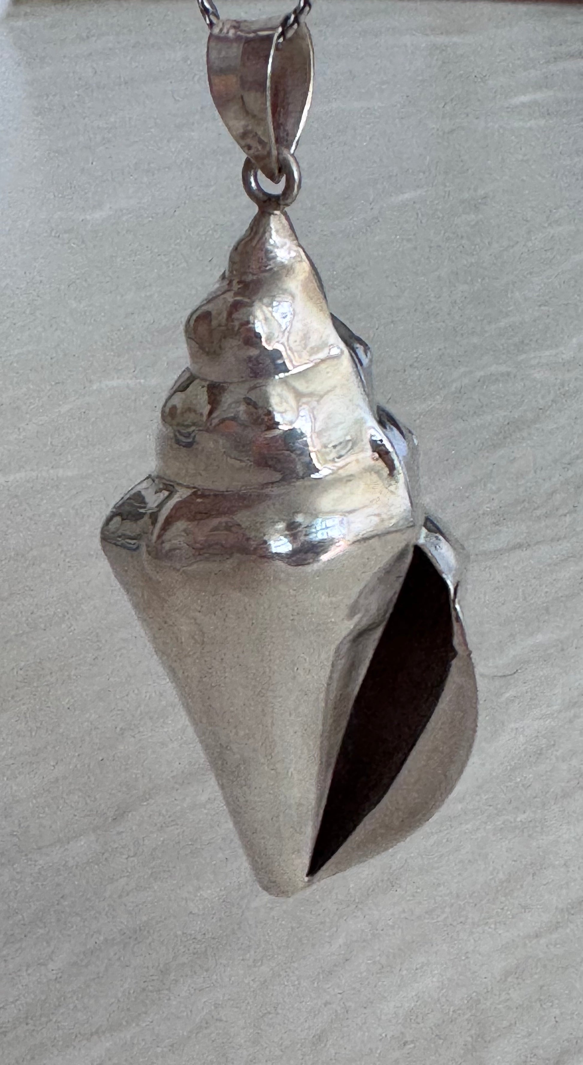 Large estate sterling silver conch shell pendant 2.75 inches long with hammered texture and included 14 inch chain, showing detailed spiral chambers