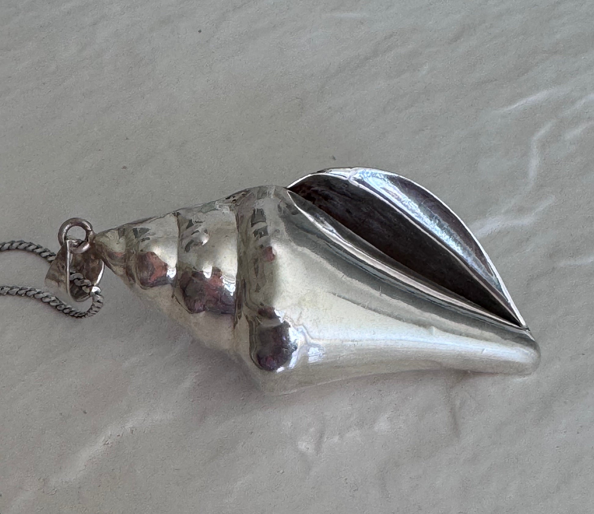 Large estate sterling silver conch shell pendant 2.75 inches long with hammered texture and included 14 inch chain, showing detailed spiral chambers